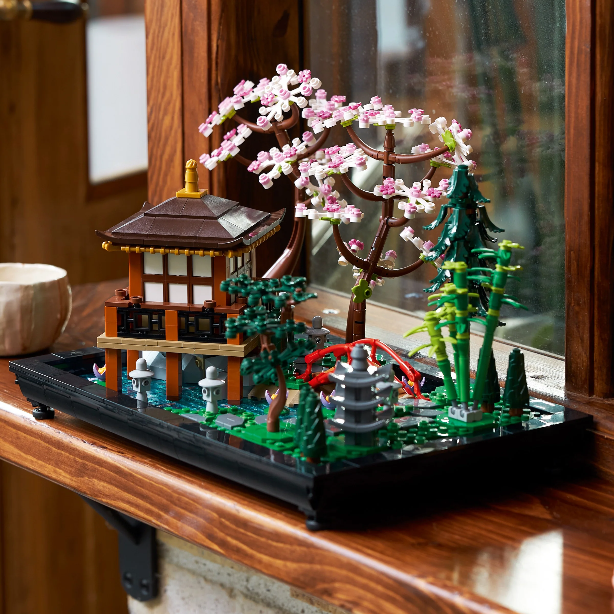 Imagine cu grădina liniștită LEGO 10315, cu templu, cireș, lac și detalii atent construite.