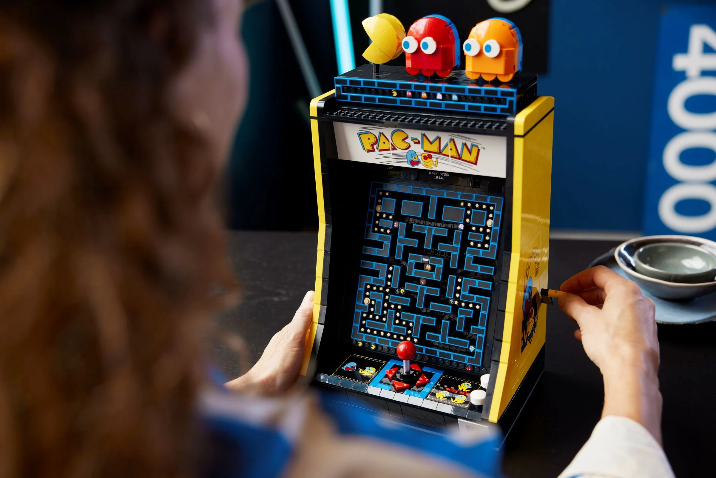 Imagine cu modelul LEGO Pac-Man Arcade 10323. Se văd detalii ale jocului și personajele Pac-Man.