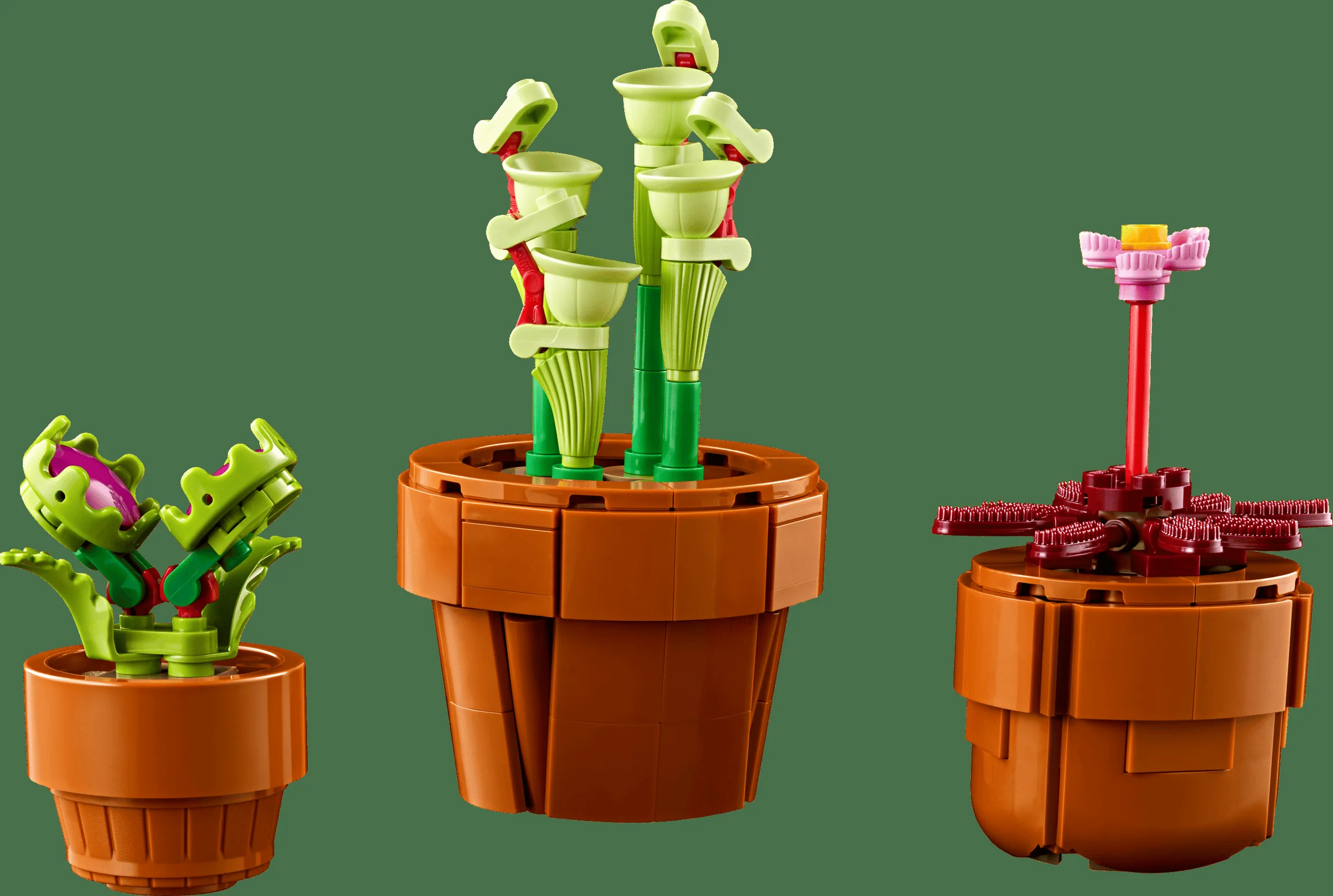 Imagine cu trei plante LEGO Tiny Plants în ghivece maro, pe fundal verde.