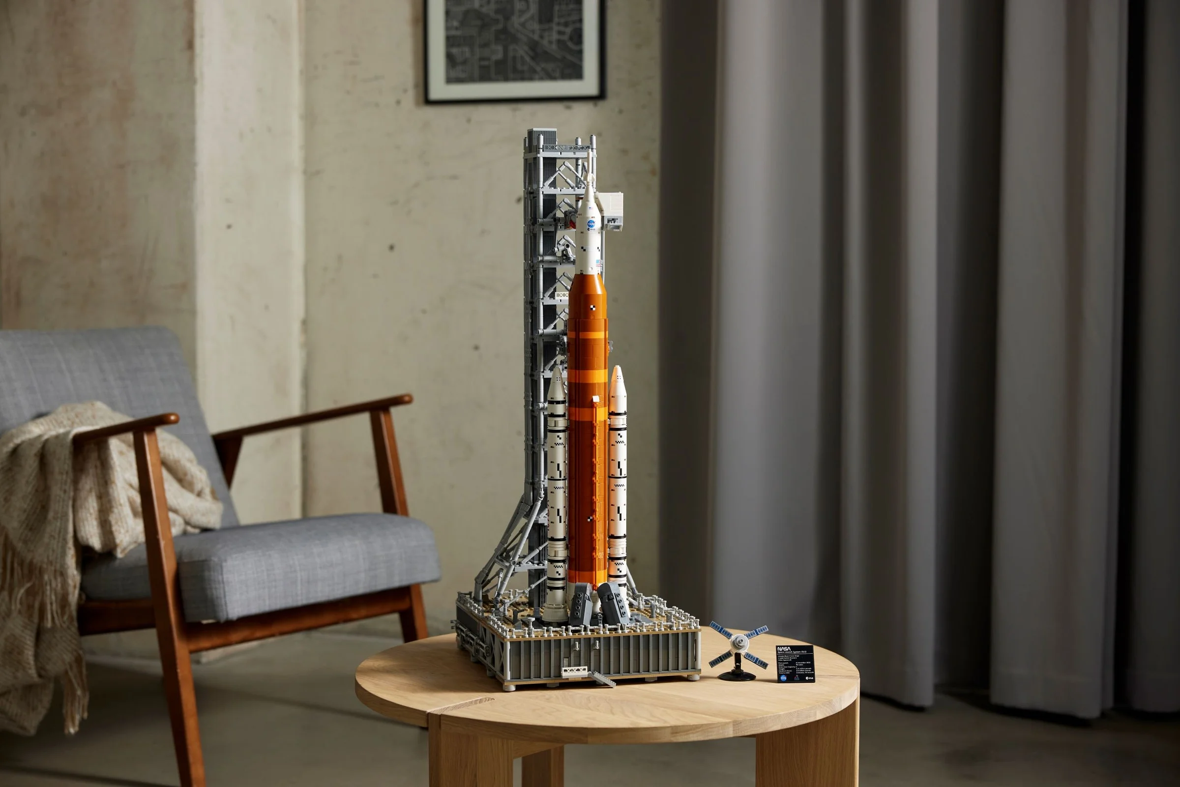 Imagine a modelului LEGO NASA Artemis Space Launch System, aranjat pe o măsuță, într-un decor modern.