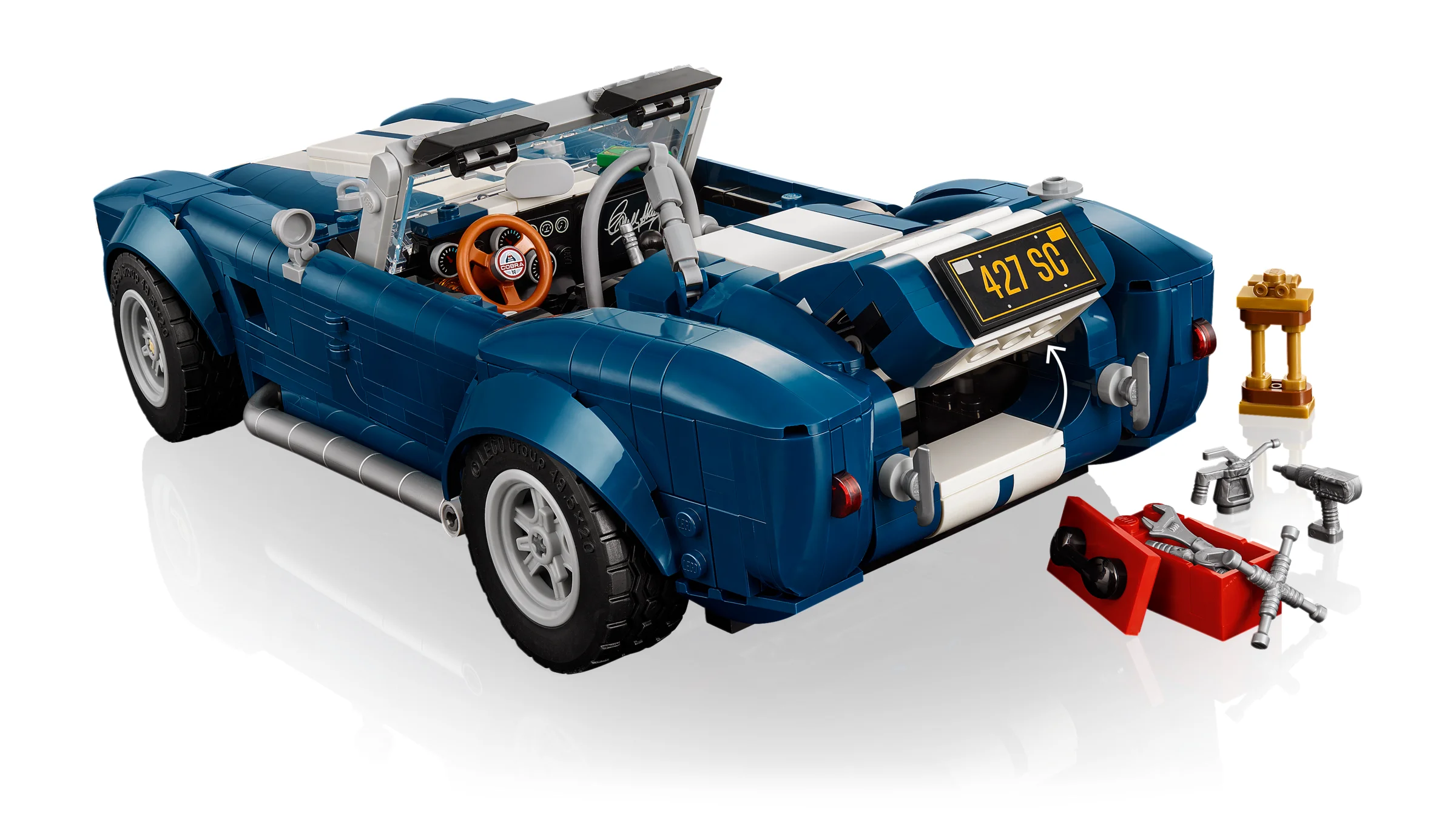 Imagine detaliată a modelului LEGO Shelby Cobra 427 S/C, cu portbagajul deschis și accesorii.