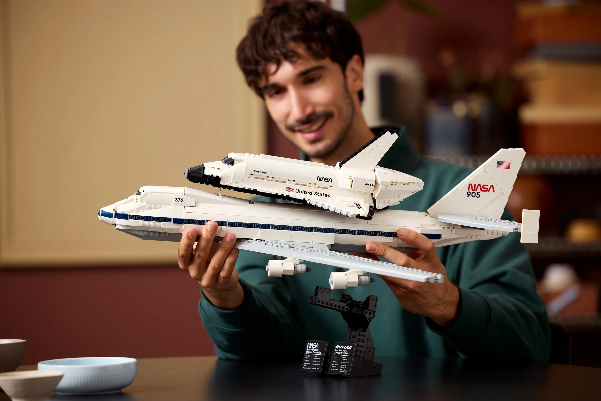 Avionul de transport navetă spațială LEGO 10360, cu naveta Enterprise montată, prezentat de un adult.