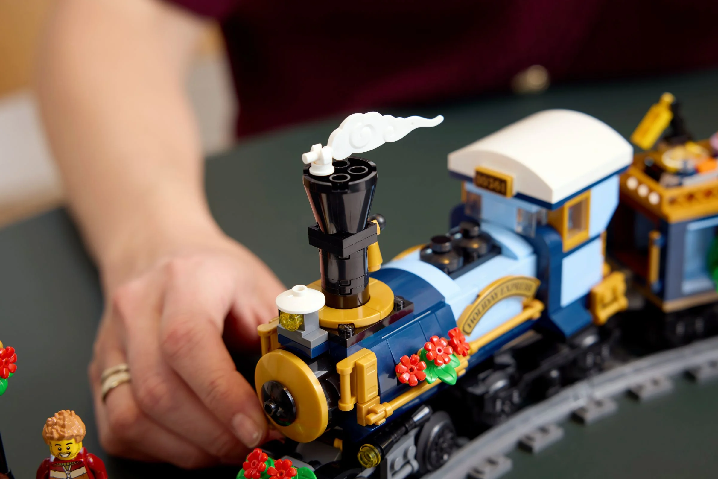 Prim plan cu locomotiva trenului Holiday Express, decorată cu flori roșii.