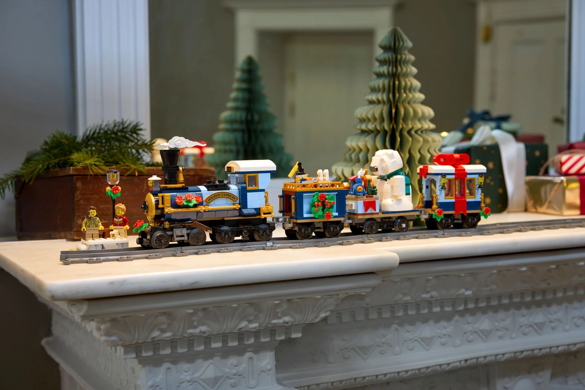 Trenul de sărbători LEGO 10361, un model festiv detaliat pe șine, cu vagoane pline de surprize.