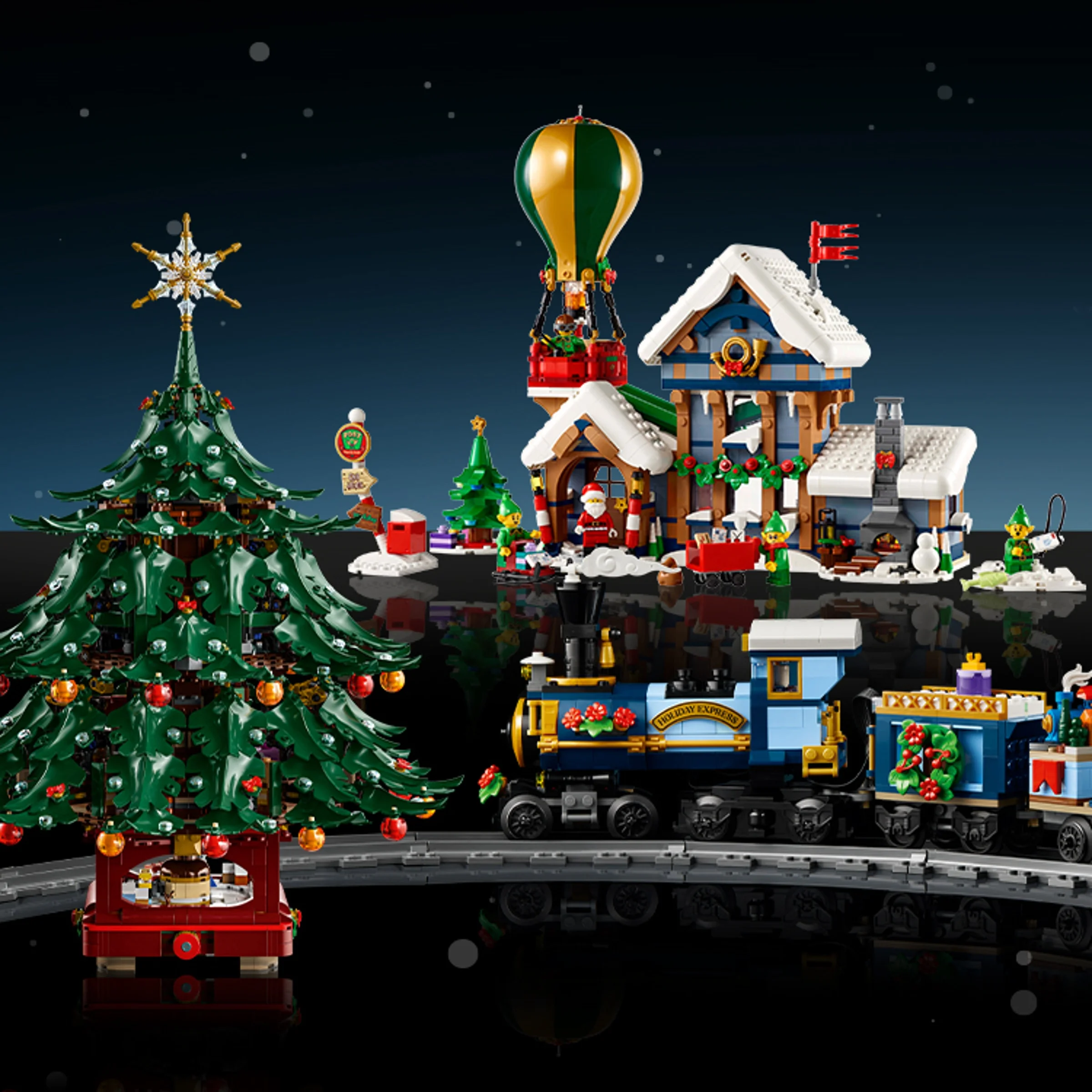 Imagine cu trenulețul de sărbători LEGO 10361, alături de gară, brad și minifigurine festive.
