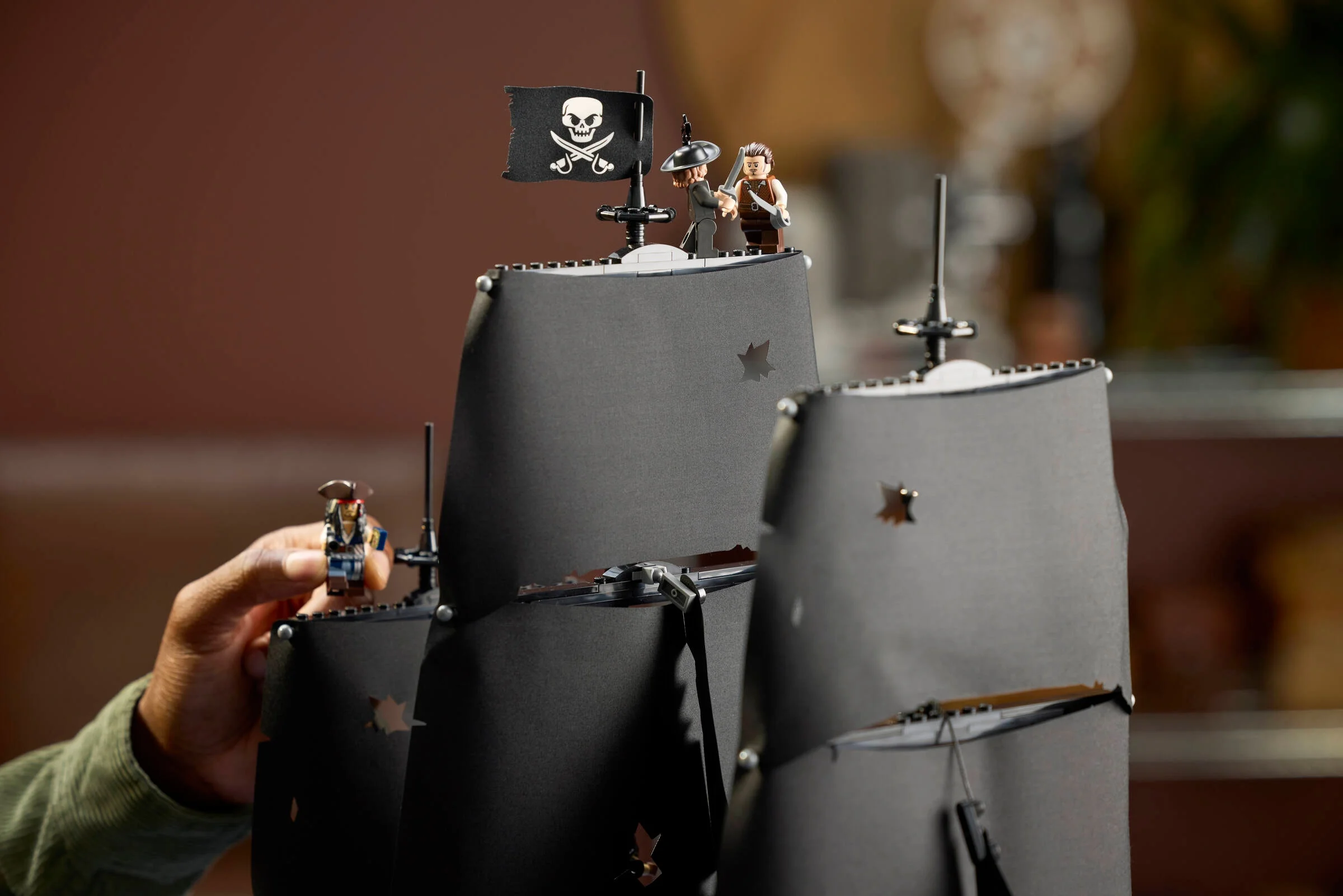 O imagine parțială a corabiei piraților, cu mini-figurine și vele negre, detaliată.