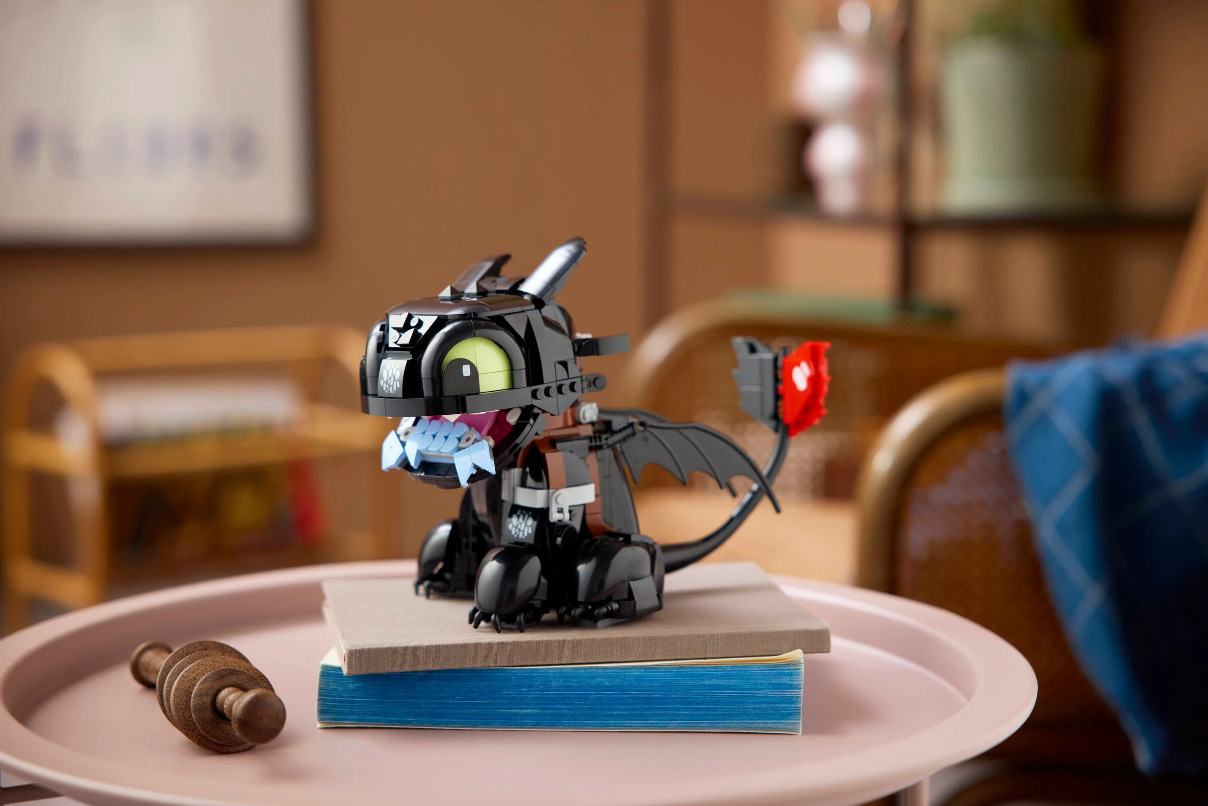 O imagine detaliată cu Toothless, dragonul construit din LEGO, așezat pe o carte.