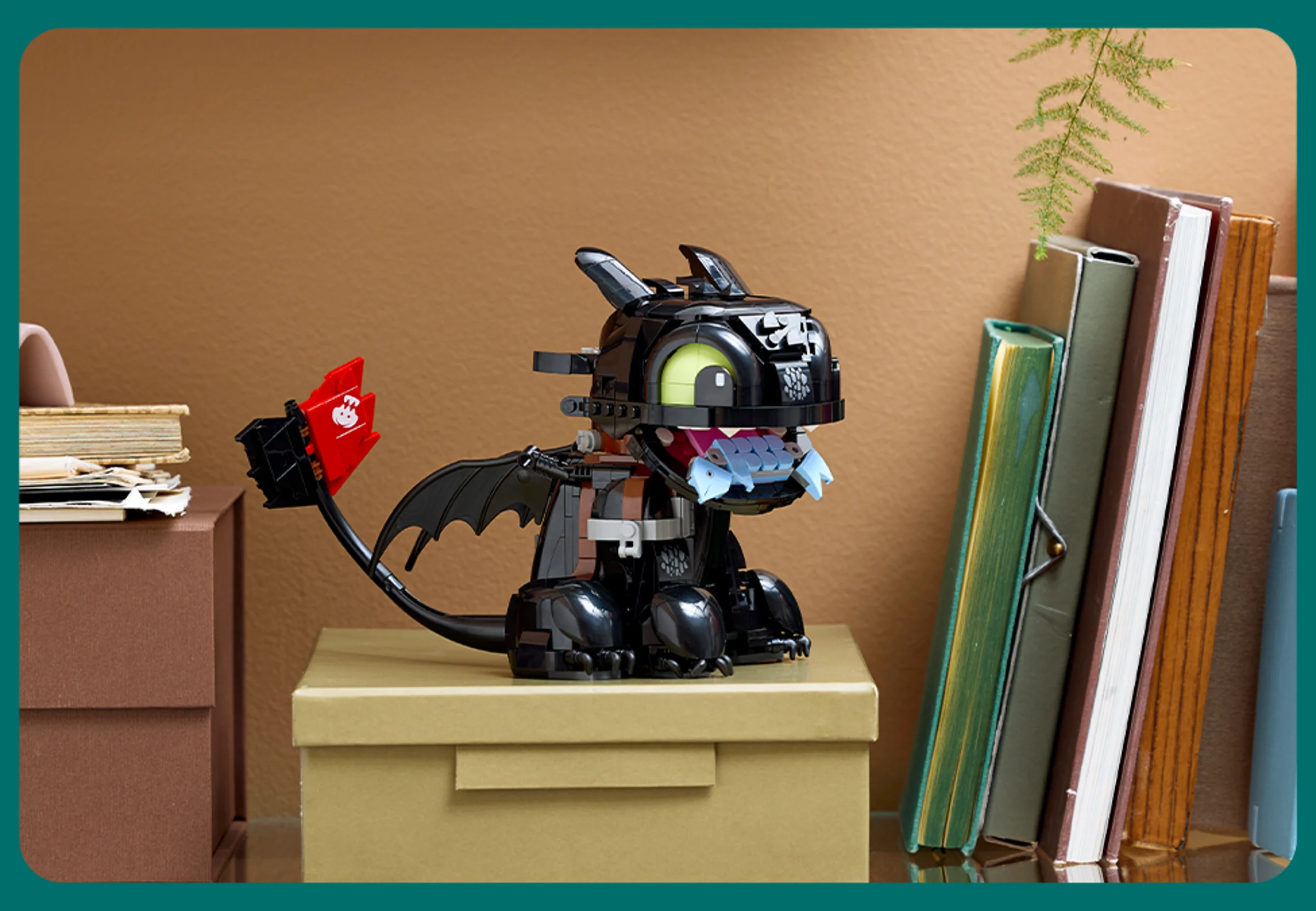 O imagine a lui Știrbul (Toothless) construit din LEGO, stând pe o cutie decorativă.