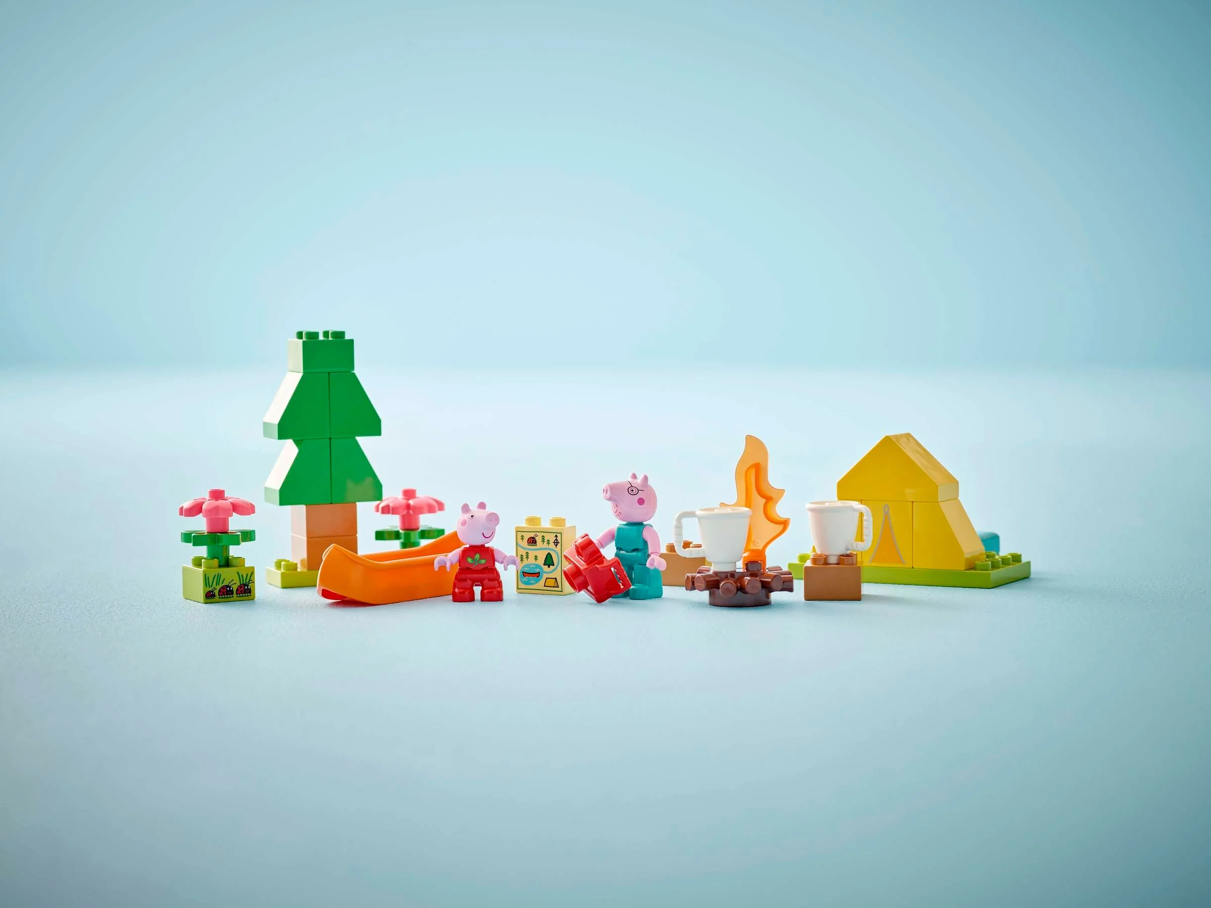 Scenă LEGO Duplo cu figurine Peppa Pig într-o excursie la camping, cu cort, foc de tabără și canoe.