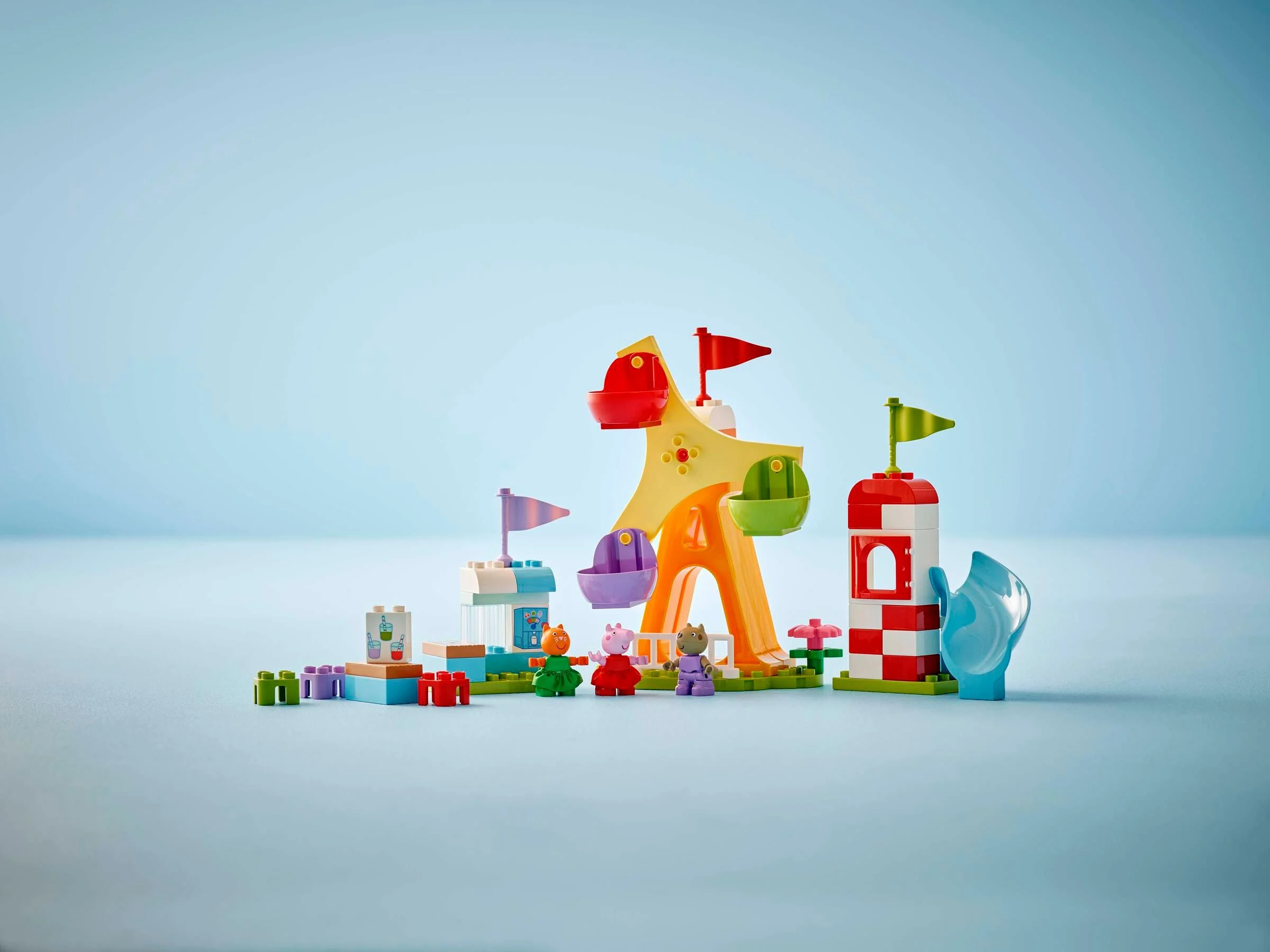 Imagine cu setul Duplo 10453 Bâlci, arătând roata, standul de băuturi și figurinele Peppa Pig.