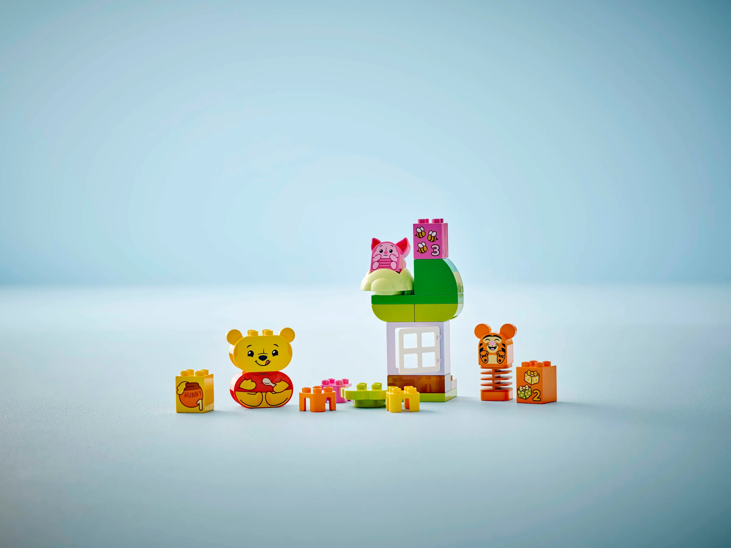 Imagine cu setul LEGO Duplo „Petrecerea de ziua lui Winnie the Pooh”, cu minifigurine și construcții.