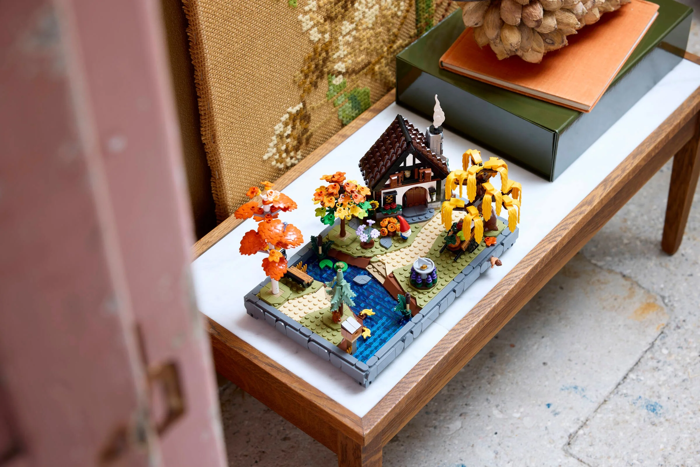 Imagine cu modelul LEGO Cabana de Toamnă (11372), detaliată și amplasată pe o măsuță.