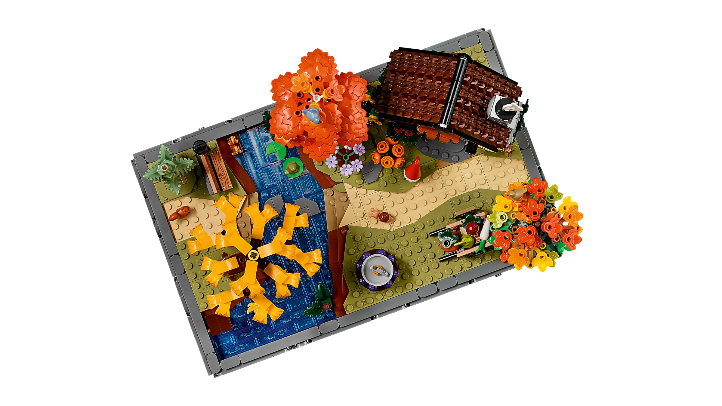 Vedere de sus a setului LEGO 11372, o grădină autumnală cu căsuță, lac și vegetație bogată.