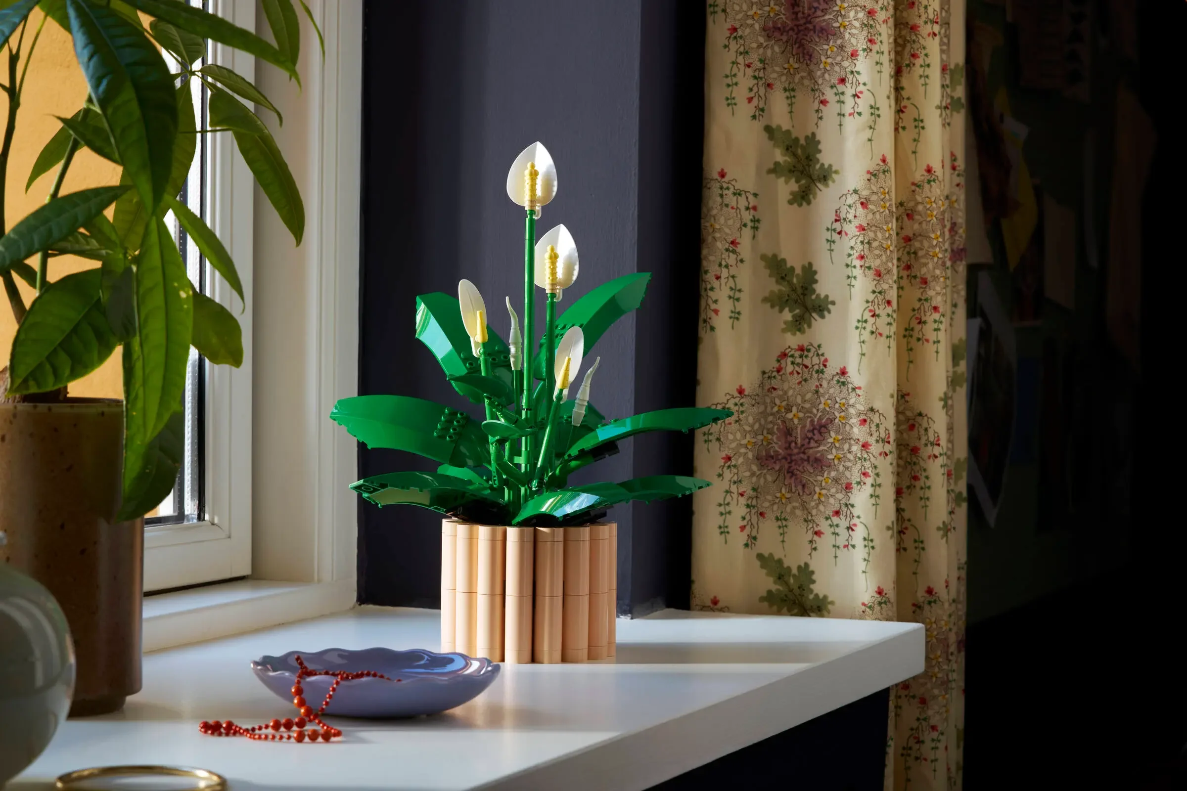 Imagine cu modelul LEGO Peace Lily (Crinii Păcii) 11504, așezat într-o încăpere decorată.