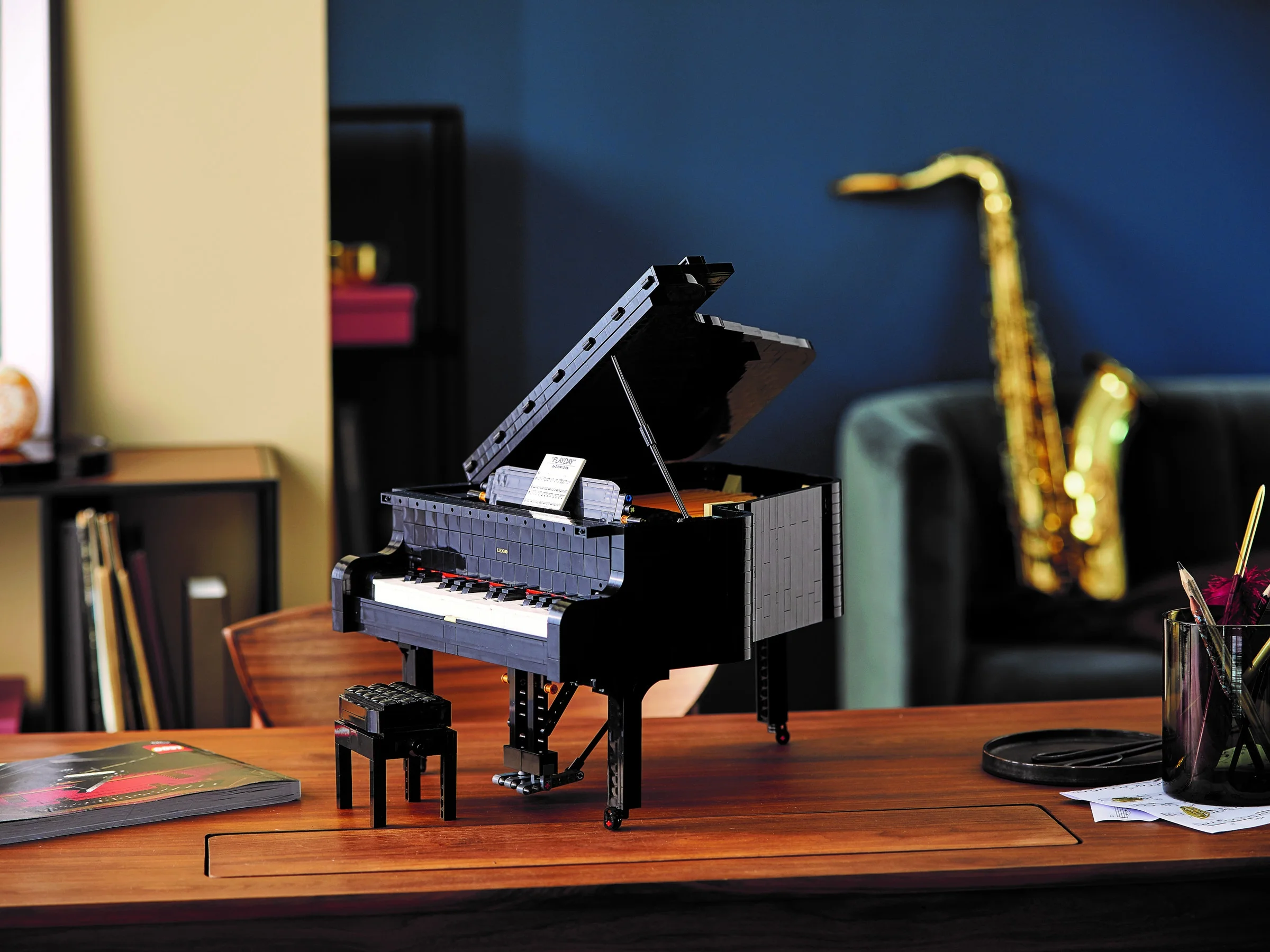 Pianul LEGO Grand Piano arată detaliat și elegant pe o masă de lemn.