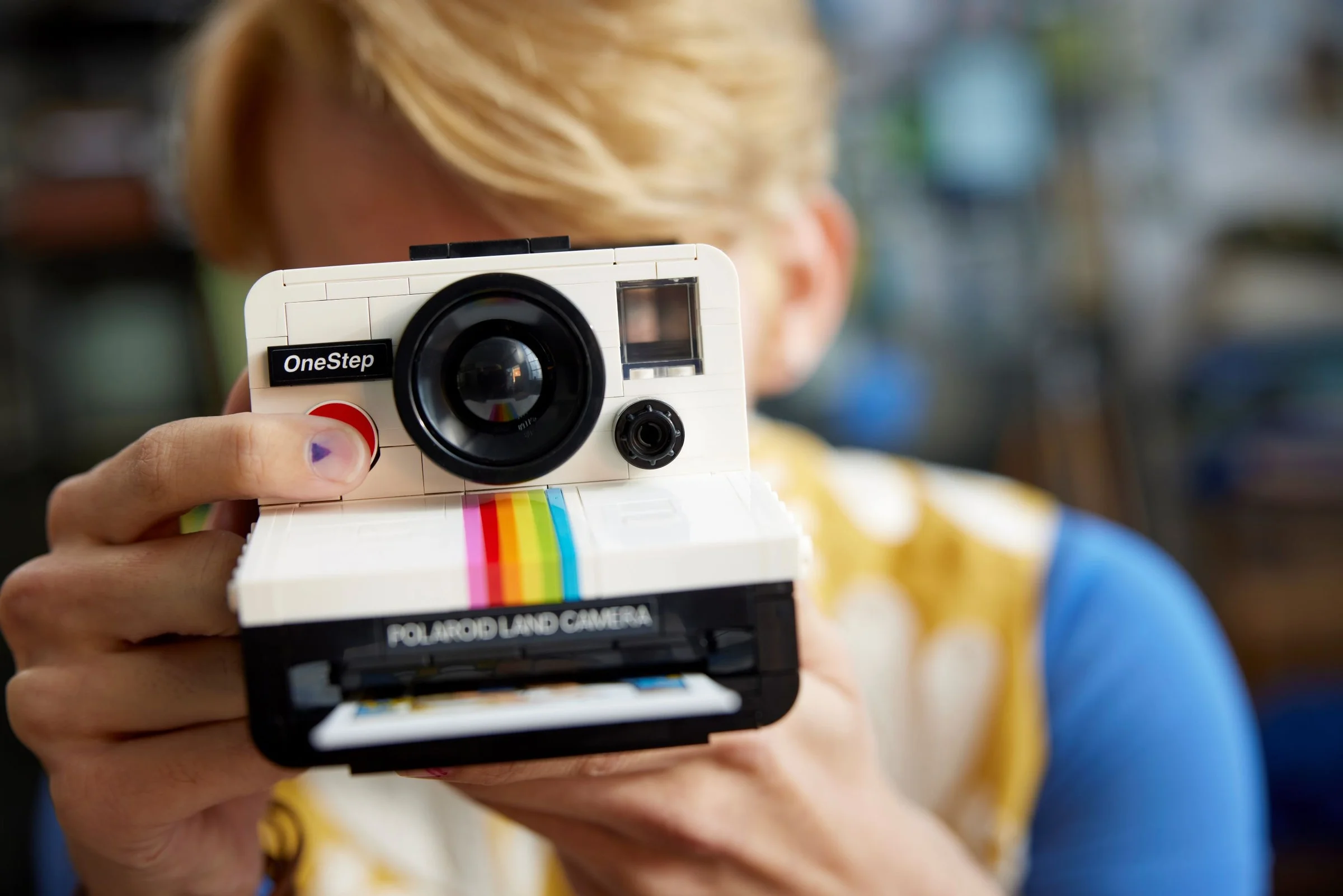 Modelul LEGO al aparatului foto Polaroid OneStep SX-70, ținut în mână. Detalii realiste.