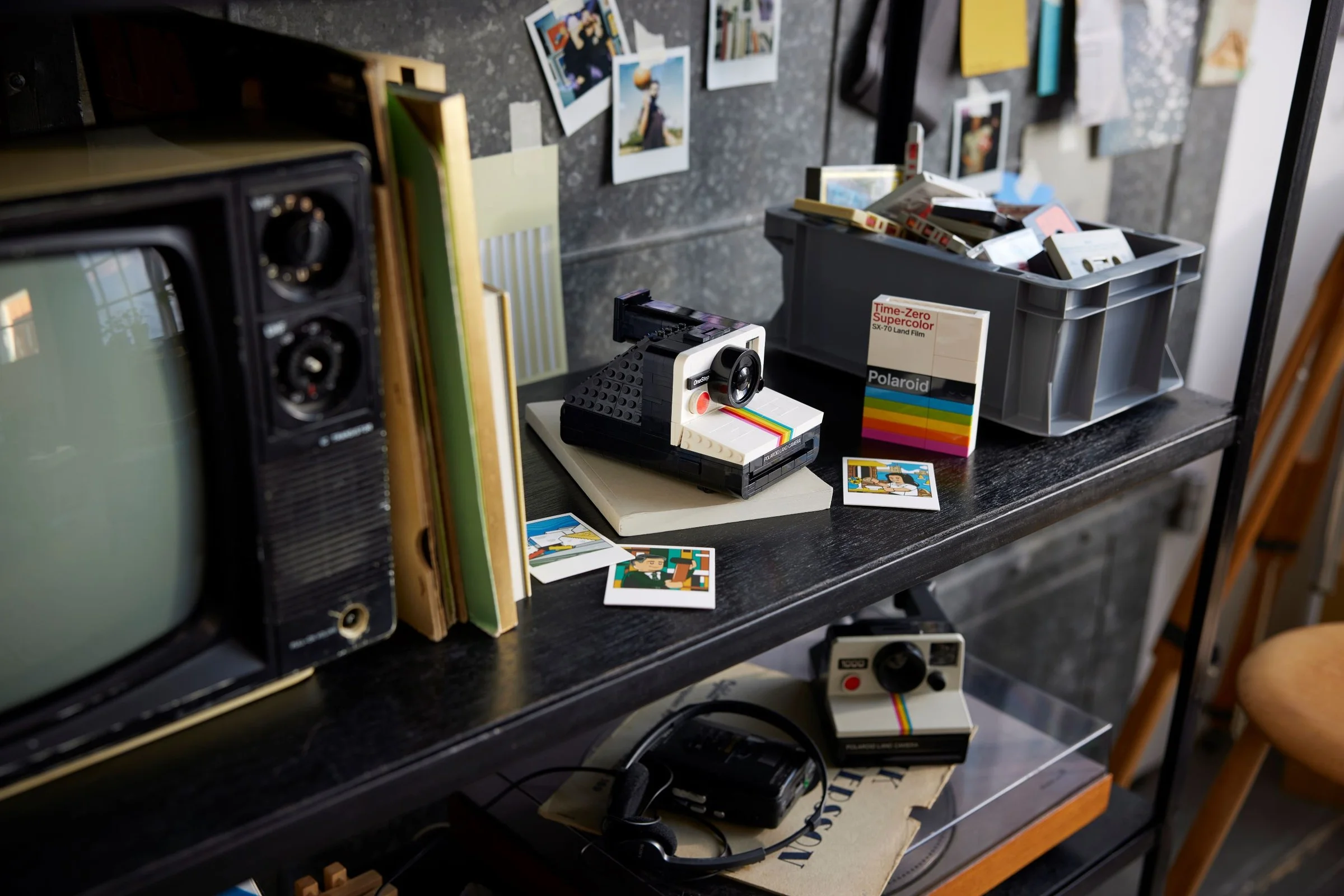 Modelul LEGO Polaroid OneStep SX-70 pe un raft cu alte obiecte vintage. O imagine detaliată.