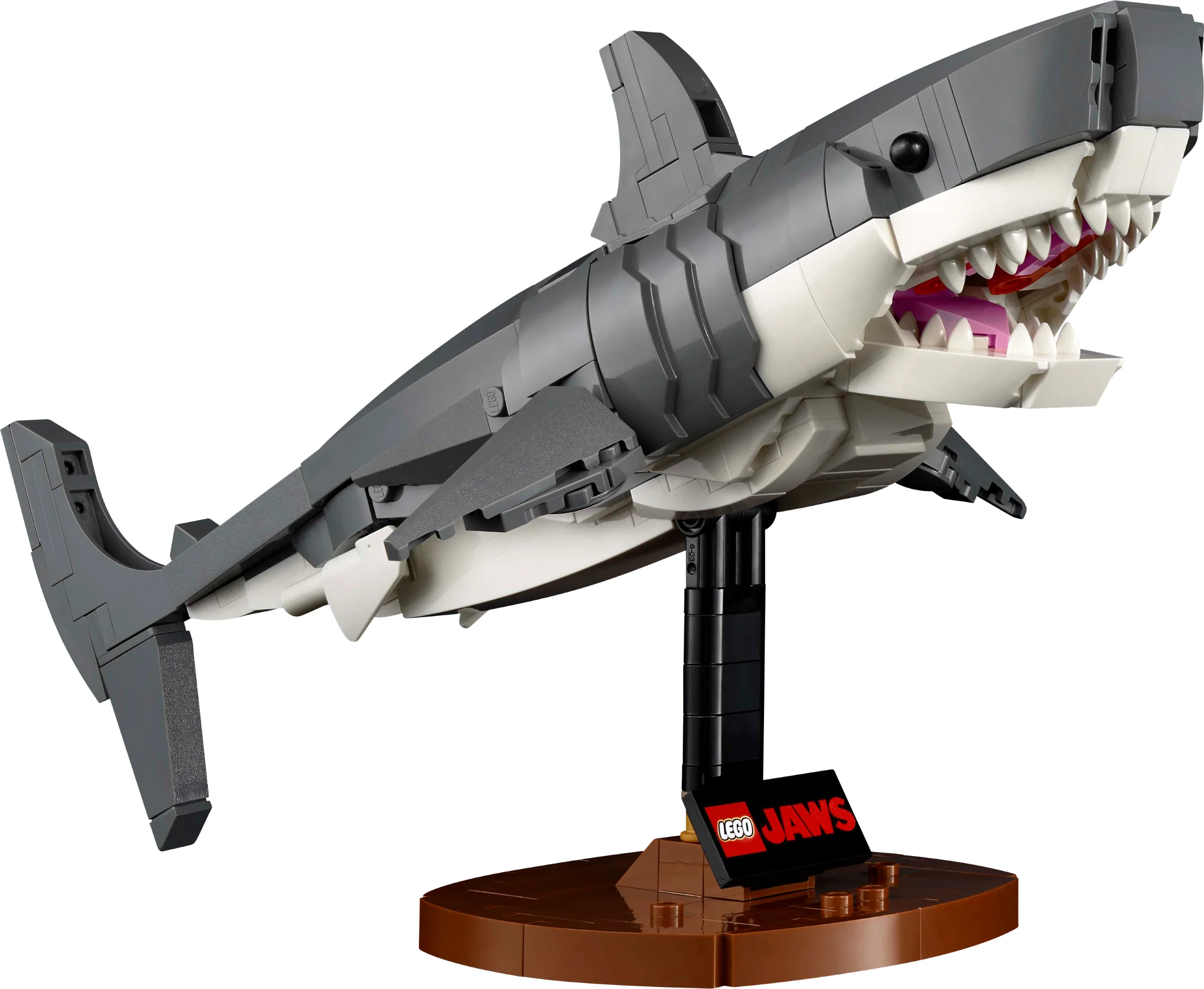 Imagine cu modelul LEGO Jaws, un rechin mare, gri, cu gura deschisă, montat pe un stativ brun.