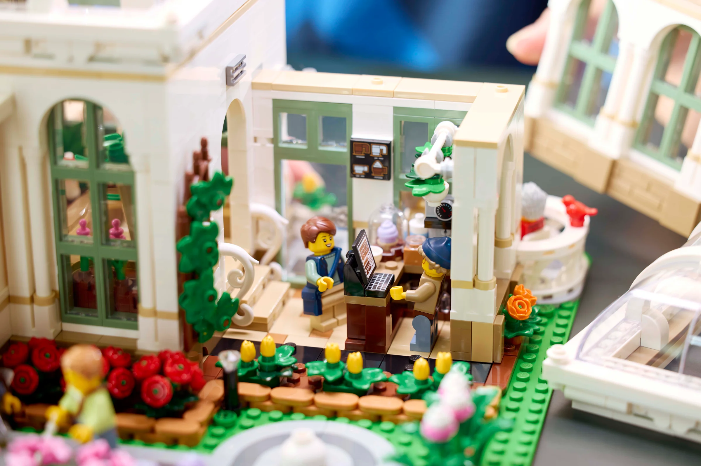 Imagine cu grădina botanică LEGO Ideas 21353, cu minifigurine și detalii ale construcției.