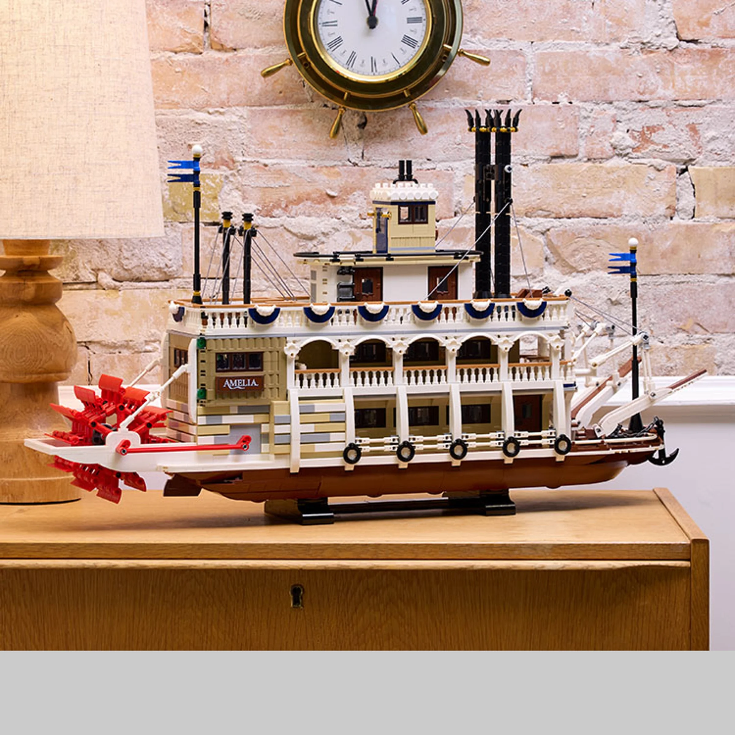 Imagine cu vaporul cu zbaturi River Steamboat (21356) LEGO Ideas, model detaliat, pe un raft.