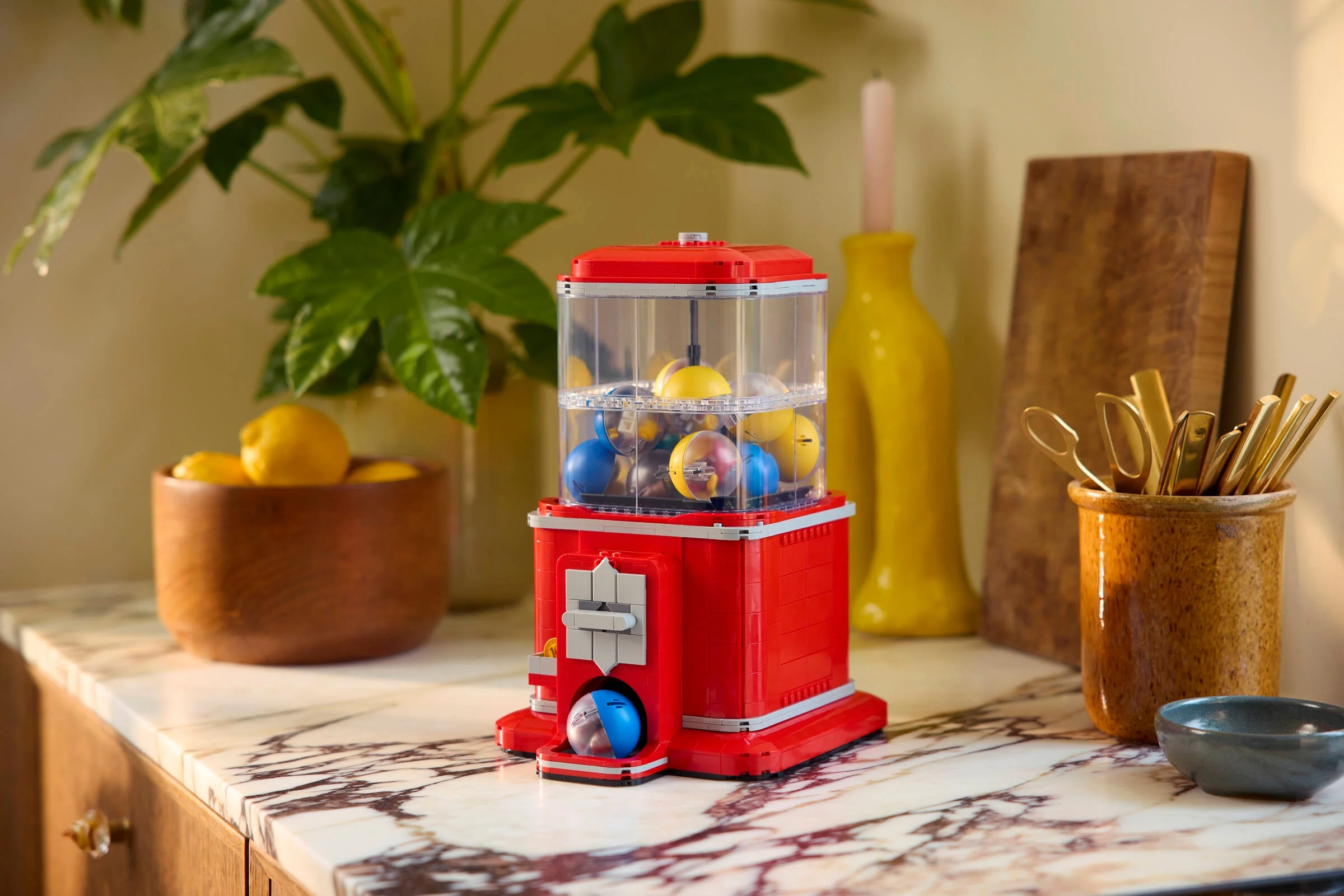 Imagine cu modelul LEGO 21358, automat de bomboane, prezentat pe o suprafață elegantă de marmură.