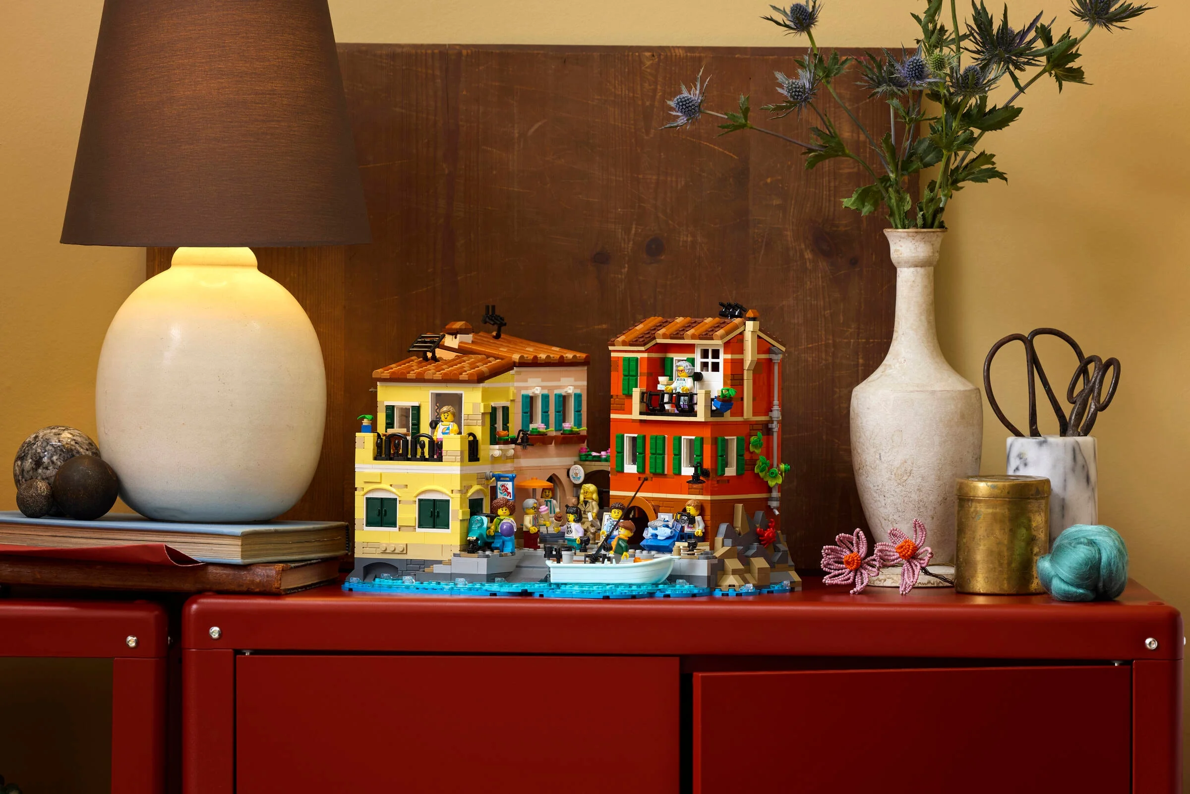 O imagine a setului LEGO 21359 Riviera Italiană, expusă pe o comodă roșie.