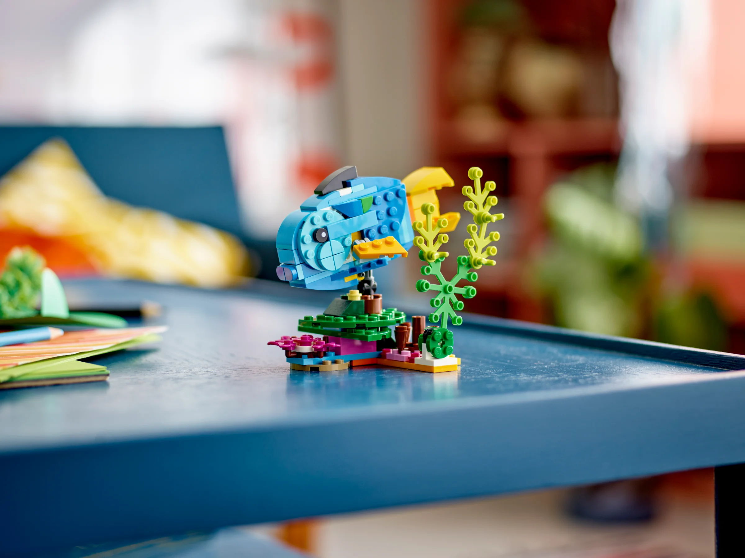 Model LEGO detaliat al unui pește exotic, viu colorat, pe un fundal estompat.