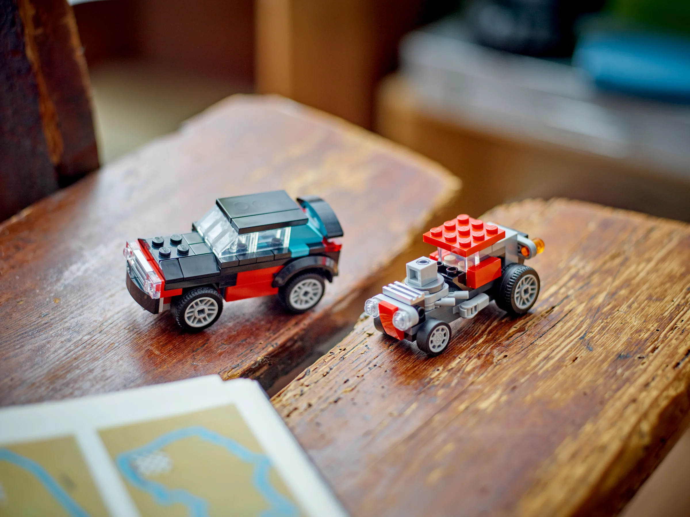 Două modele LEGO alternative ale setului 31146, un autoturism și un hot rod, pe o suprafață de lemn.