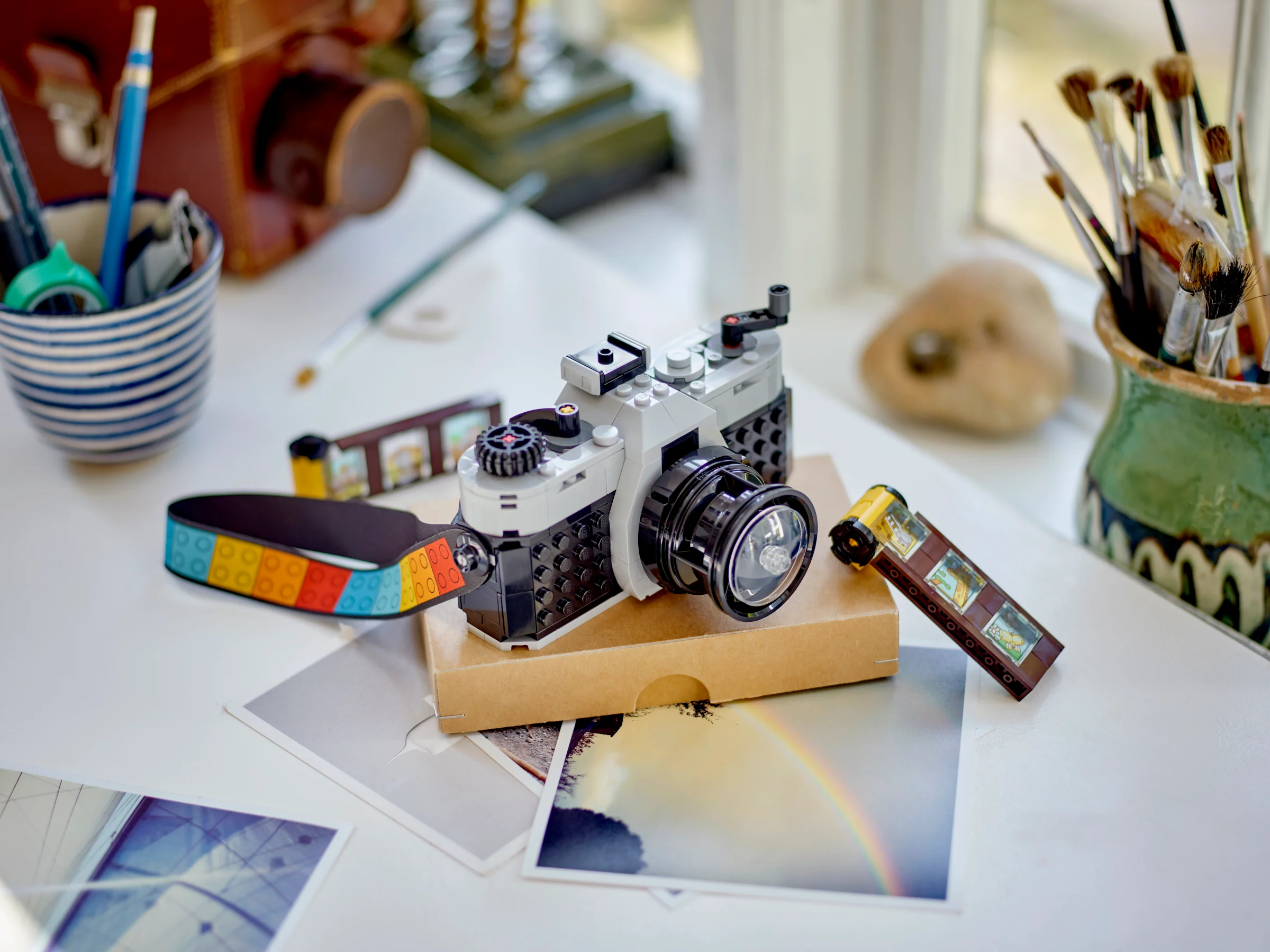 Camera retro LEGO Creator 31147, expusă cu role de film și poze printate.