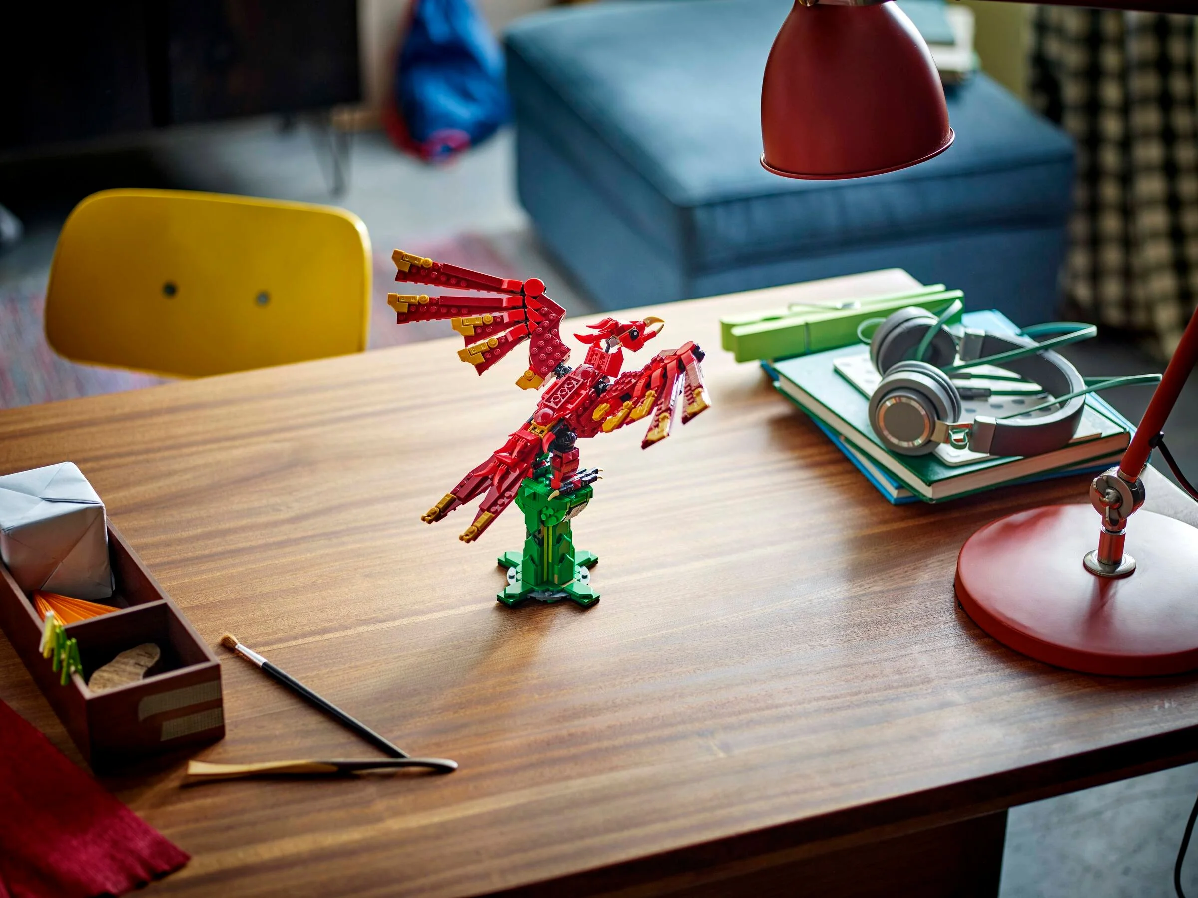 Dragonul LEGO Creator, roșu și auriu, pe un suport verde, pe o masă. Detaliu al setului.