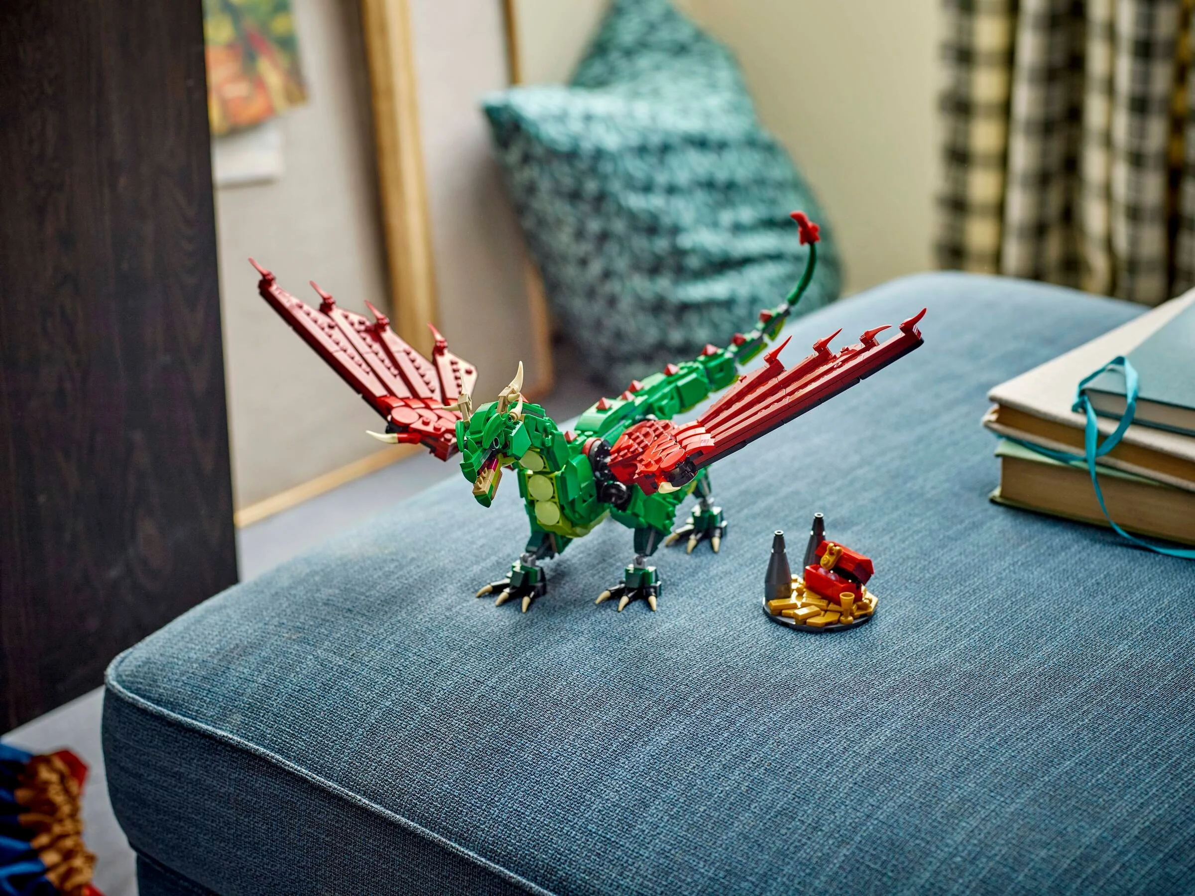 Dragonul medieval LEGO Creator 31161, verde și roșu, lângă o comoară mică pe o canapea.