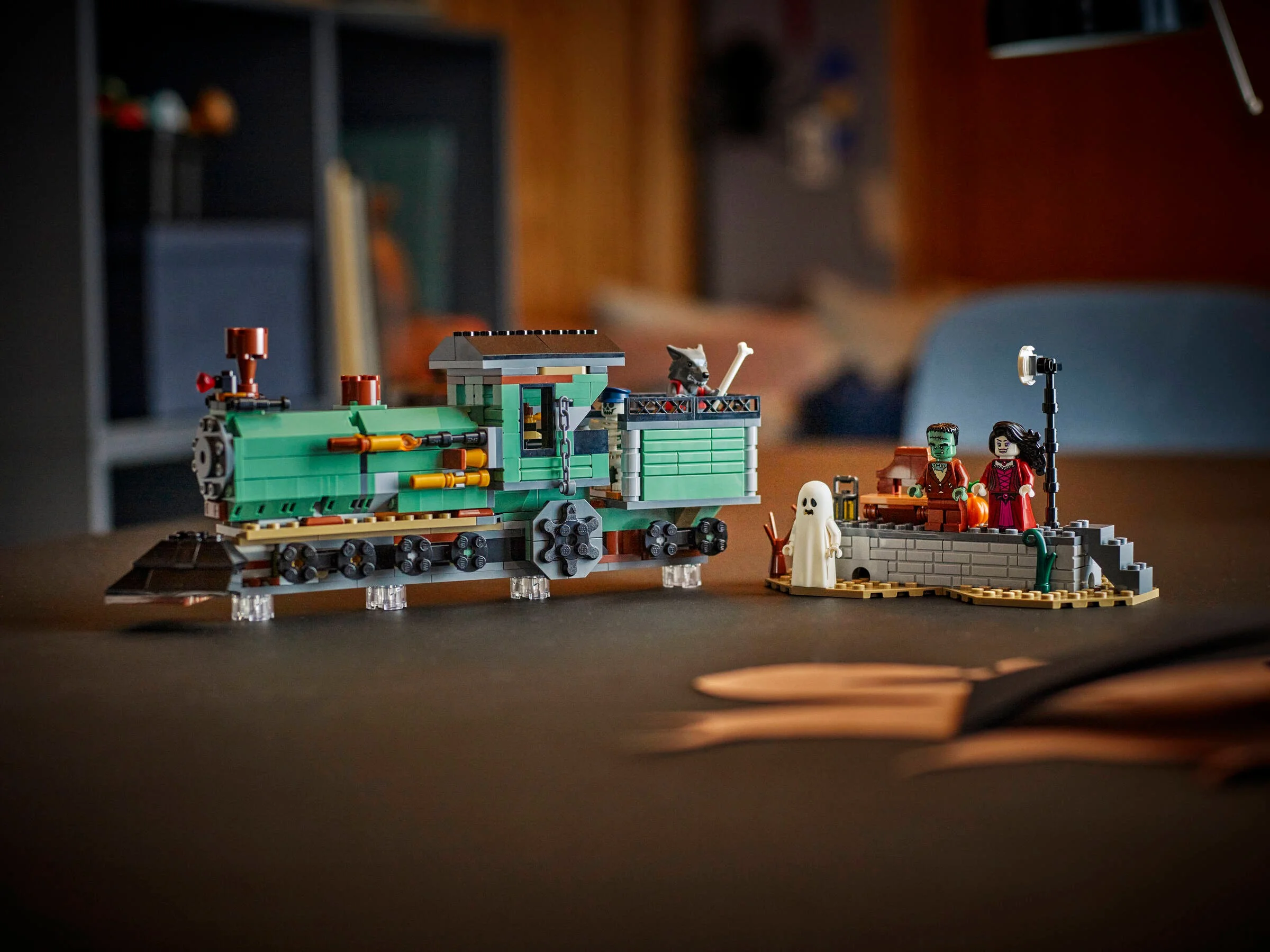 Trenul bântuit și minifigurinele LEGO Creator 31167, pe o masă. Atmosferă misterioasă.