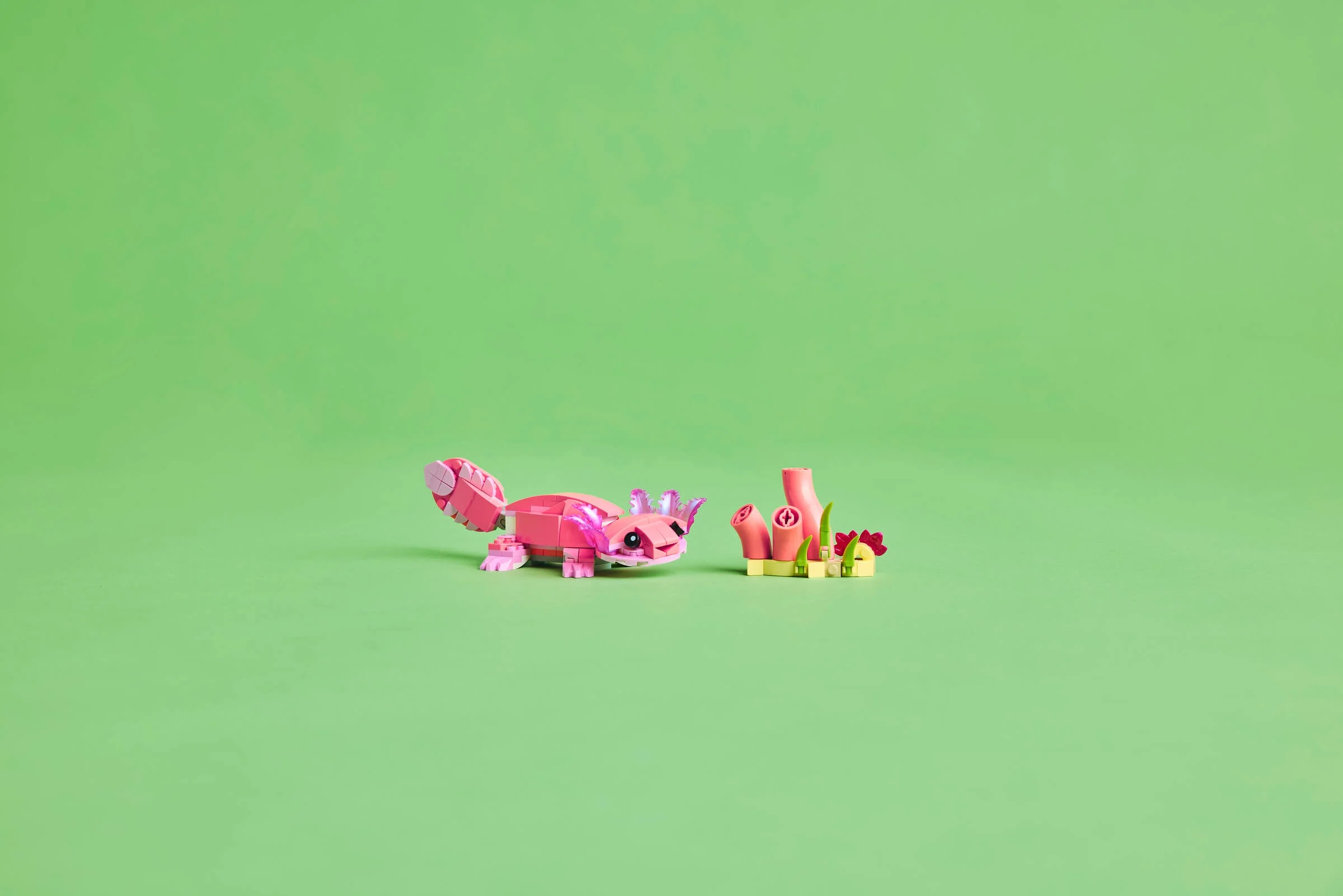 Axolotl roz din cărămizi LEGO, cu corali colorați. Model simpatic și detaliat.