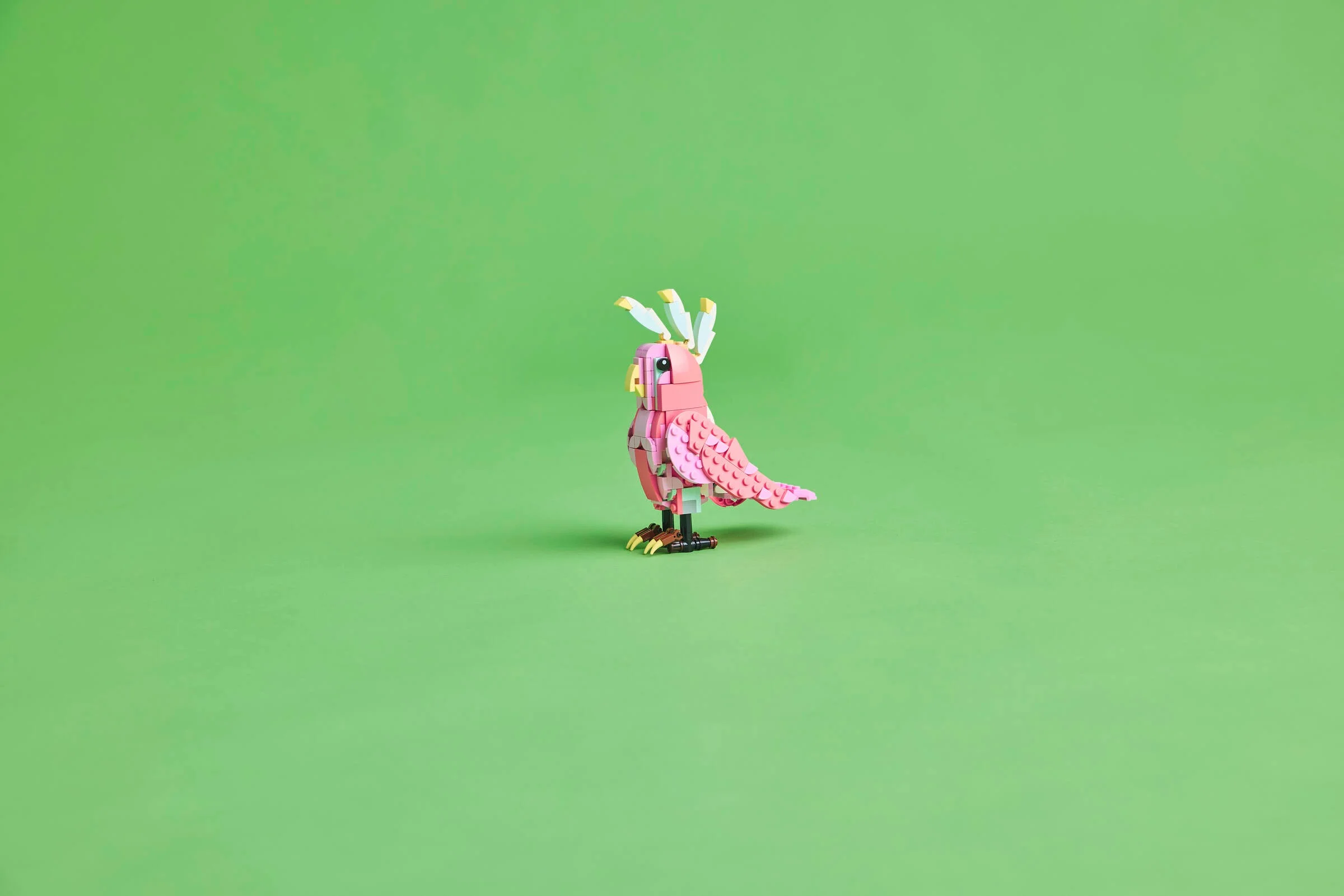 Model detaliat al unui papagal roz LEGO Creator, atrăgător și plin de culoare.