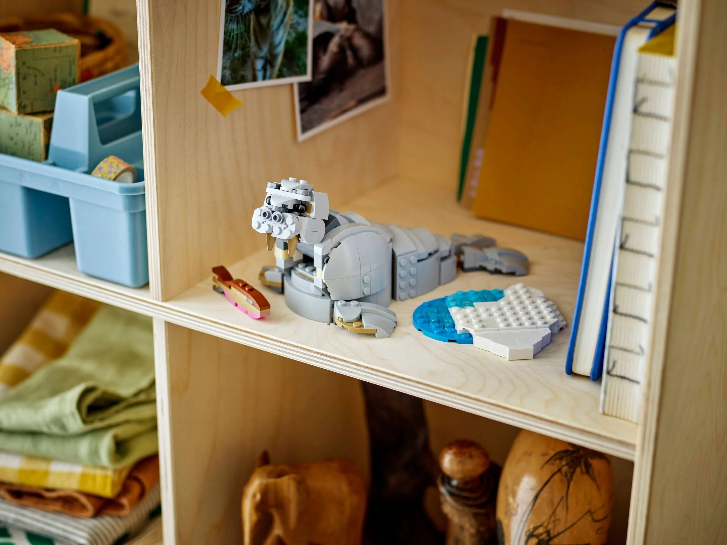 Un morse LEGO Creator 3 în 1, model finalizat, expus pe un raft de lemn cu alte obiecte decorative.