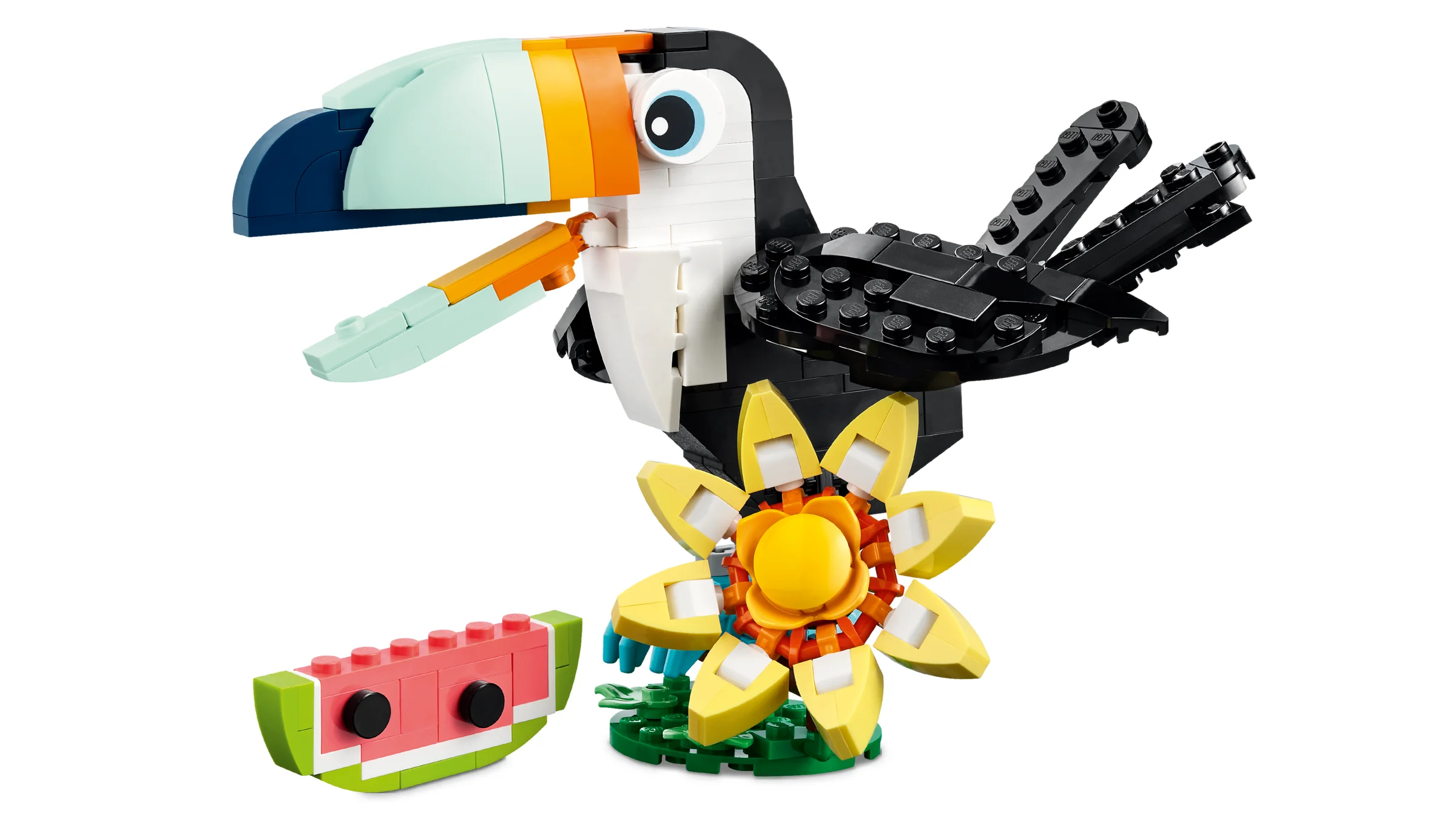 Imagine cu un tucan tropical LEGO detaliat, lângă o felie de pepene și o floare.