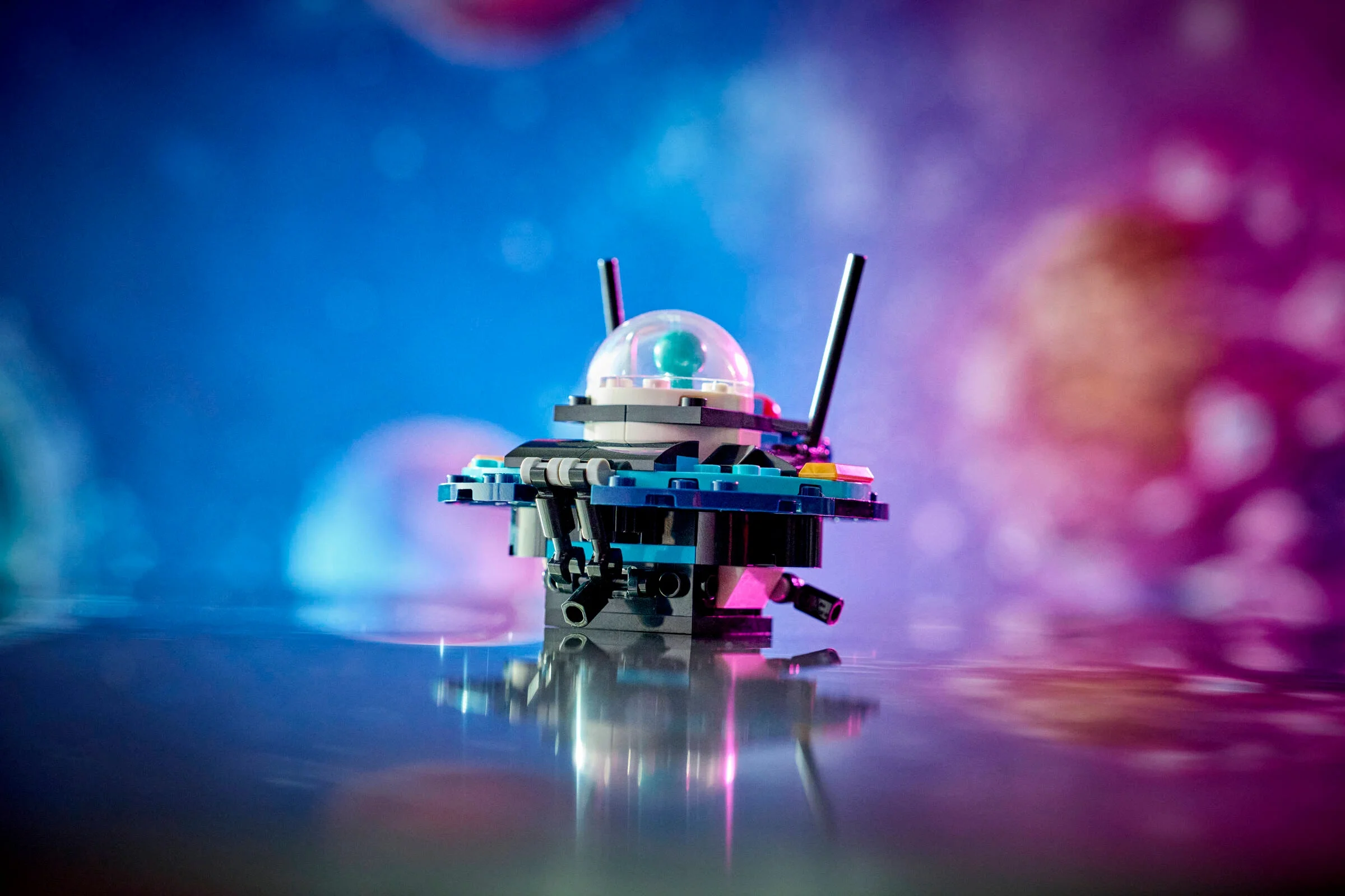 Model LEGO al unui telescop spațial cu cupolă transparentă, pe un fundal colorat. Detaliu atractiv.