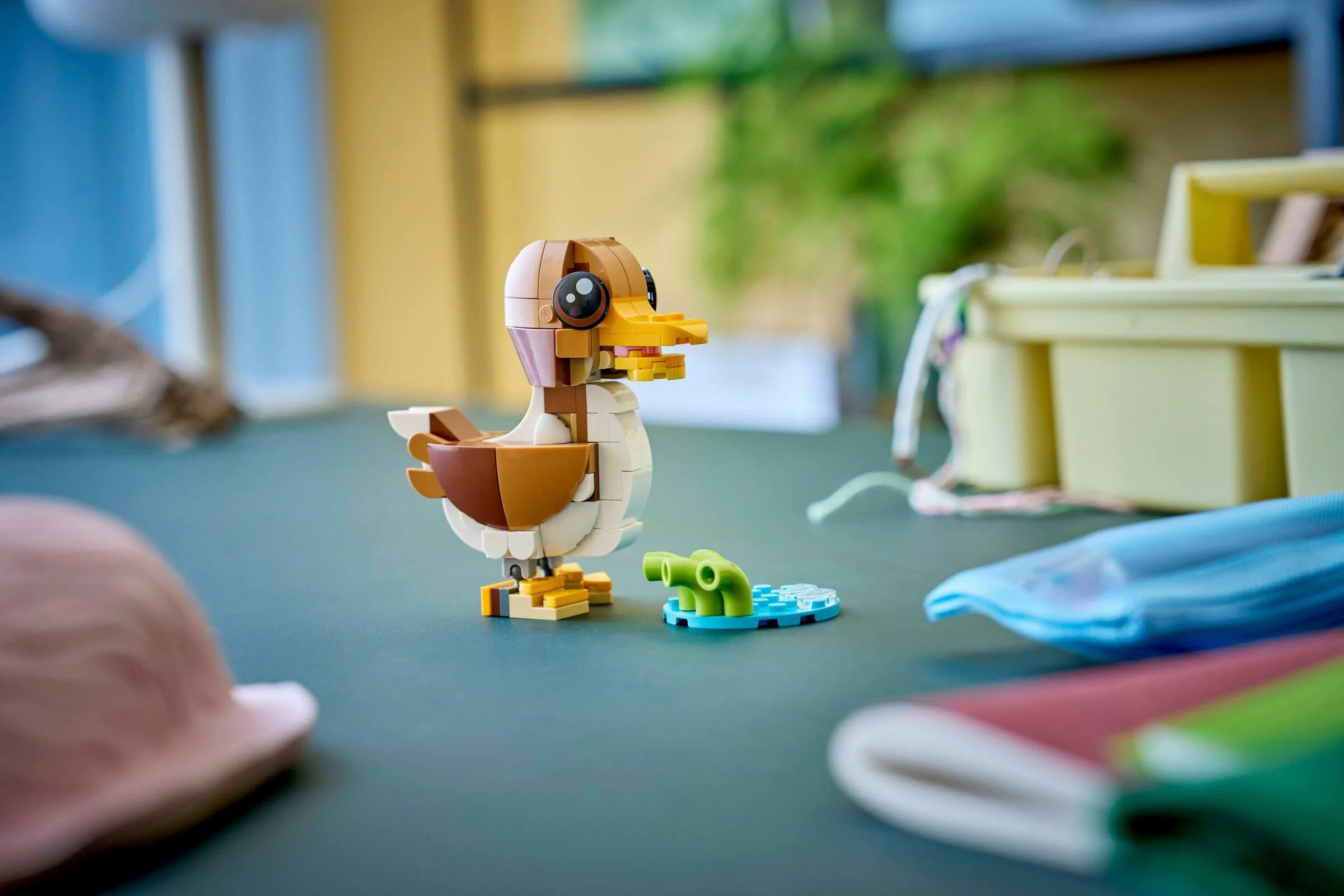 Un pui de rață LEGO maro și alb, pe un fundal estompat. Jucărie creativă.