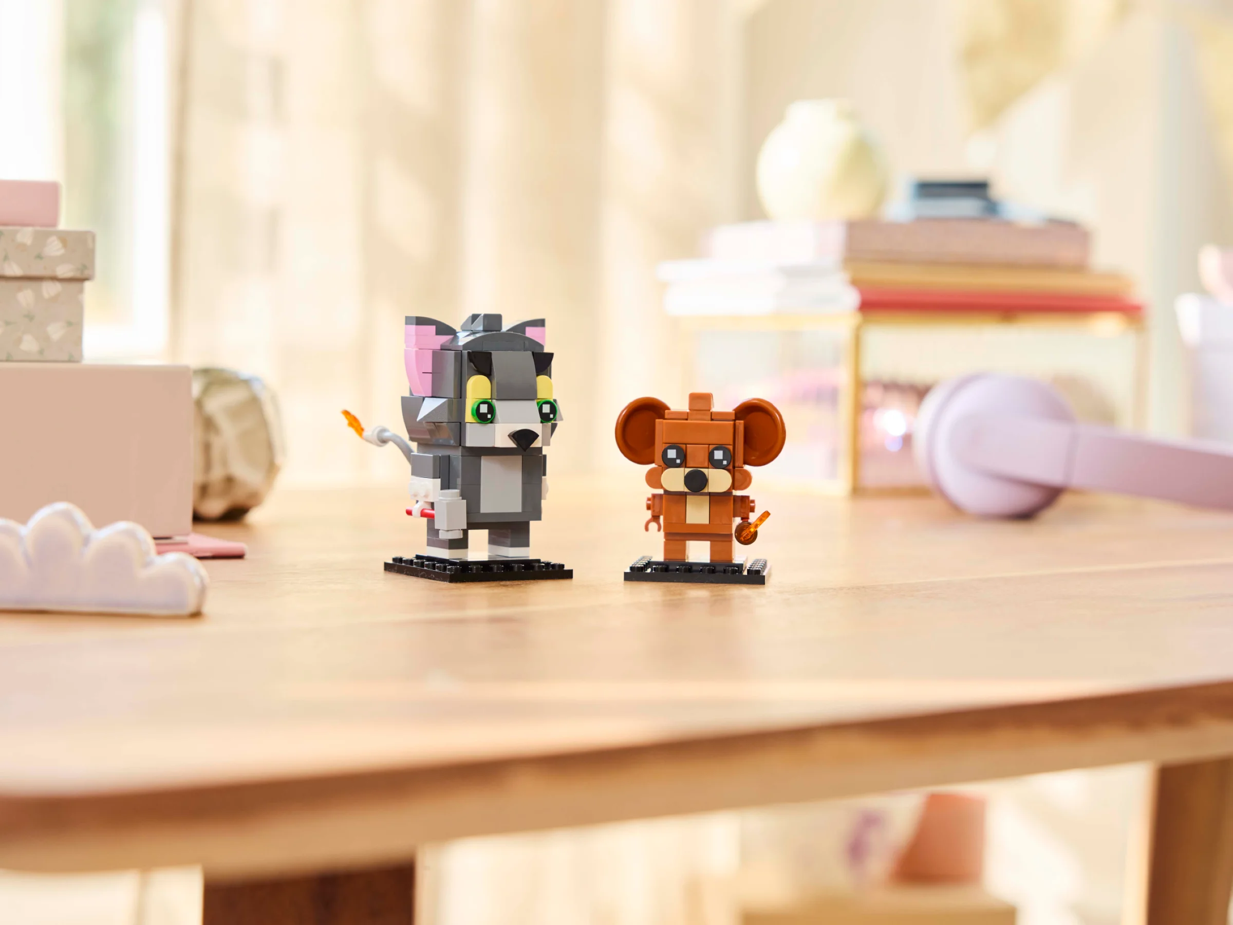 Imagine cu figurinele Tom și Jerry BrickHeadz, pe o masă de lemn într-un cadru domestic.