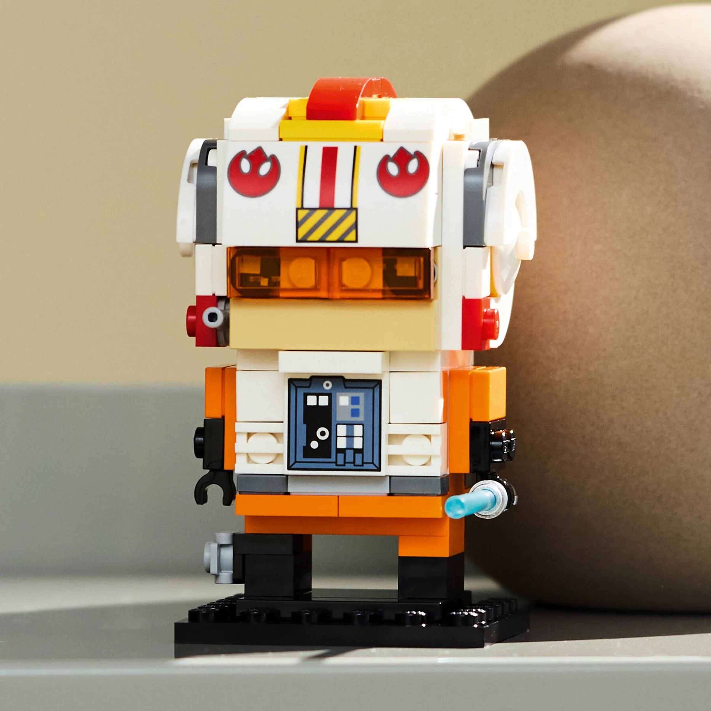 Prim-plan cu figurina BrickHeadz Luke Skywalker în ținută de pilot rebel, detaliată și colorată.