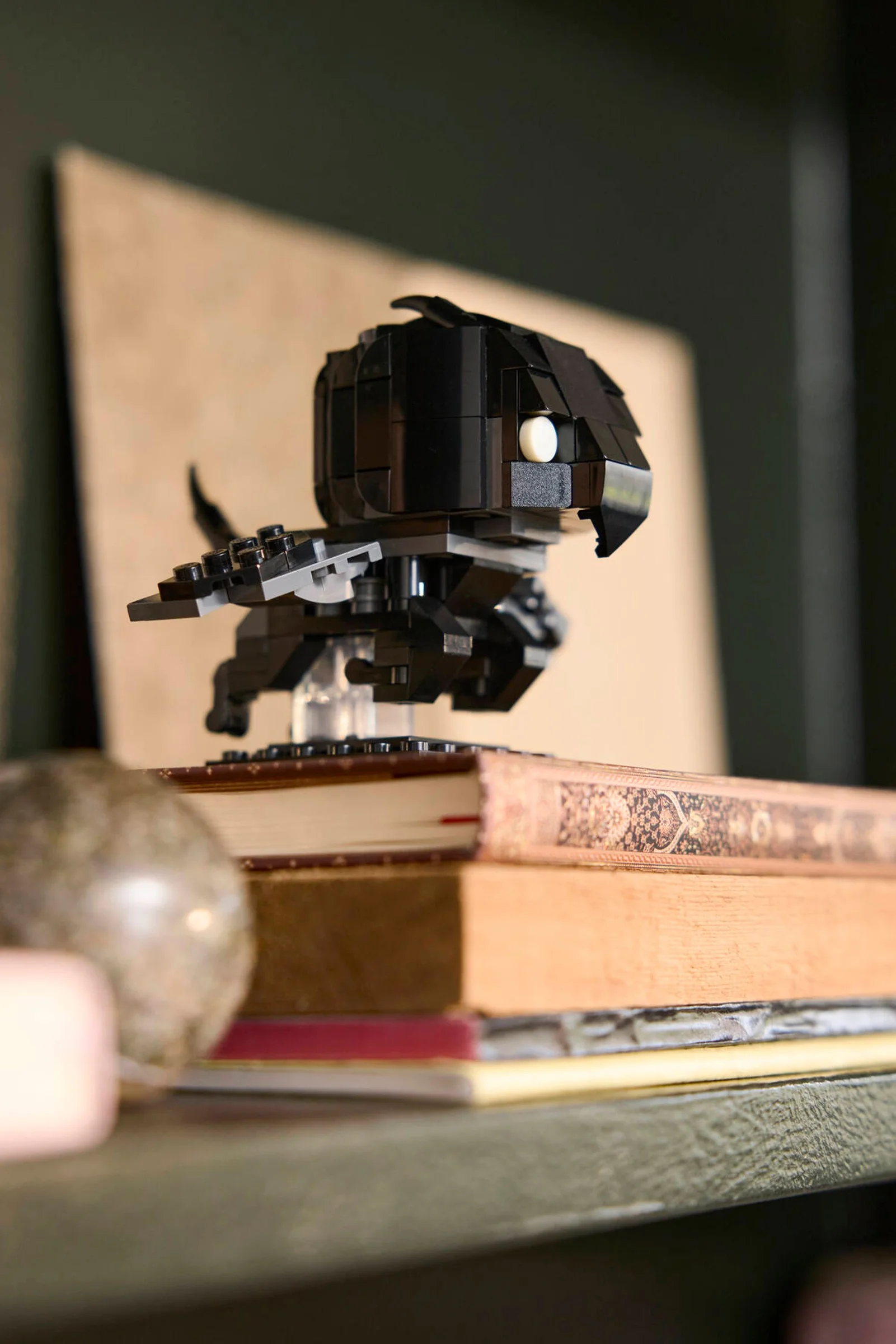 Thestral BrickHeadz negru, așezat pe cărți. Model detaliat, ideal pentru fanii Harry Potter.
