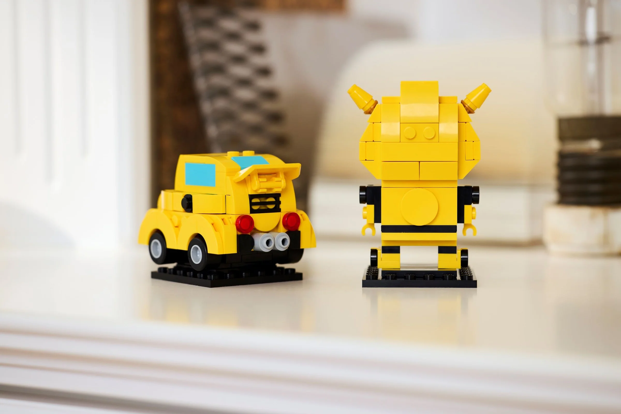 Imagine cu Bumblebee BrickHeadz, modelul mașină și robot expuse. O jucărie atractivă pentru fani.
