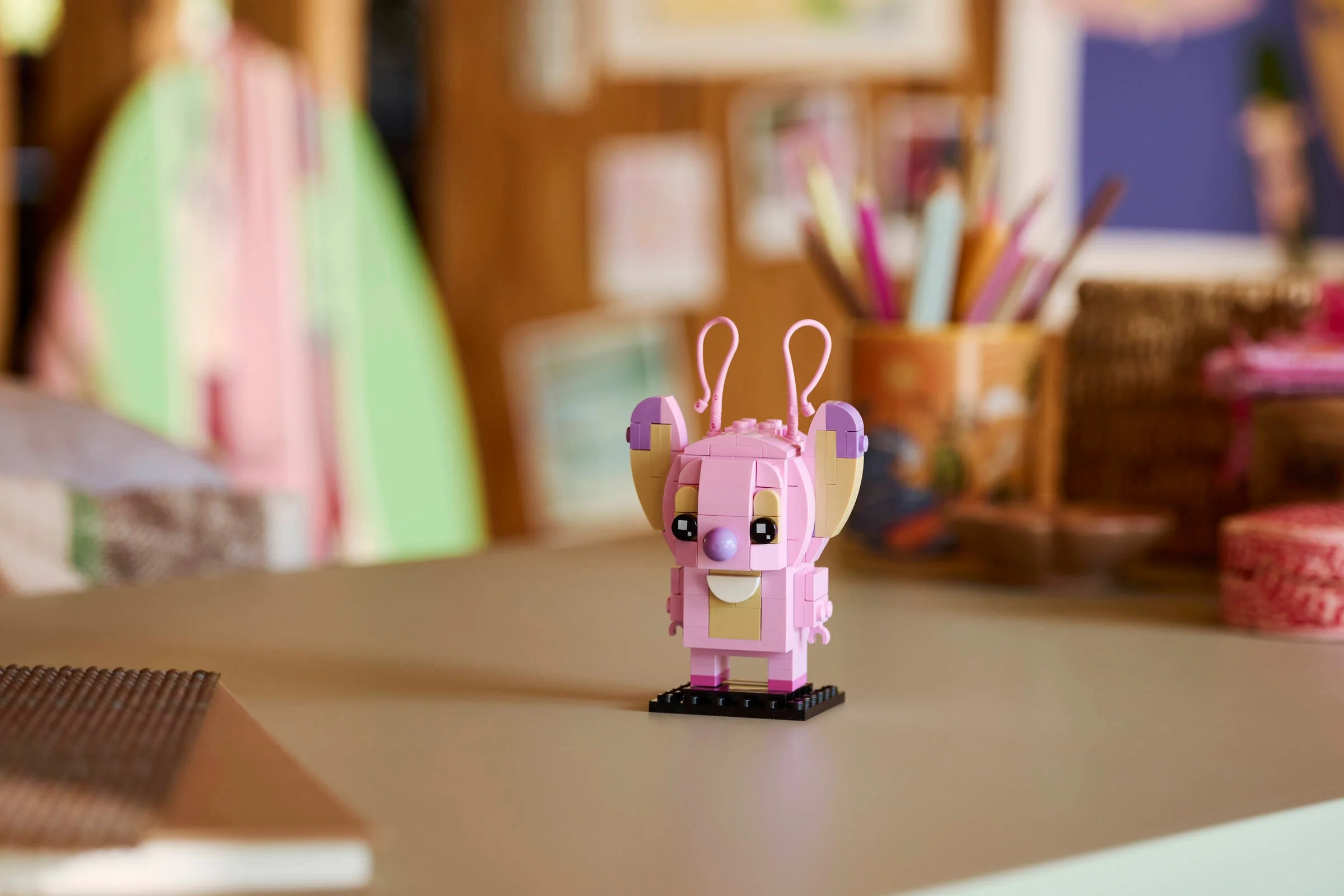 Imagine cu Angel BrickHeadz (40922) pe un birou, într-un cadru creativ și colorat.