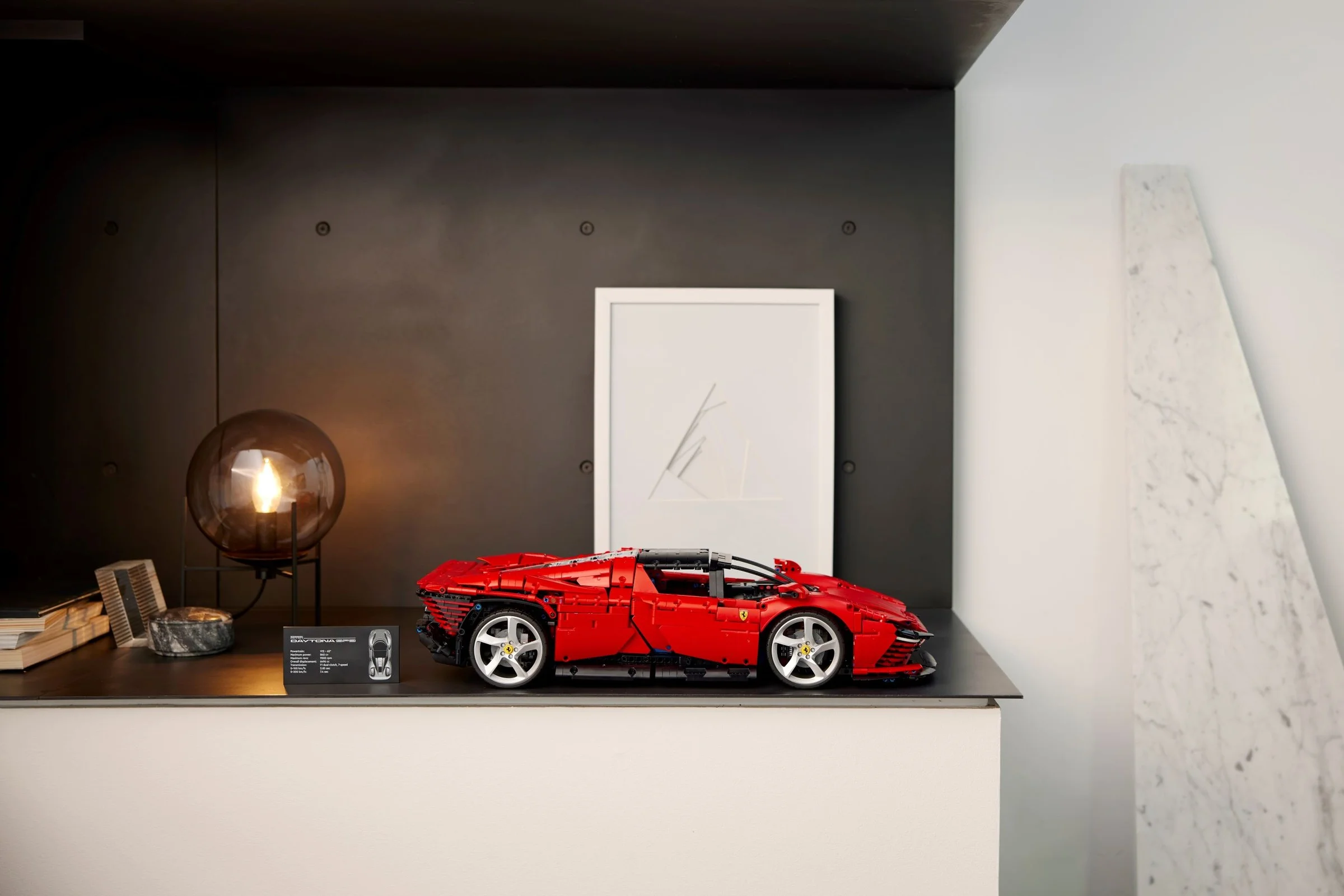Imagine cu modelul Ferrari Daytona SP3 roșu, expus pe un raft modern. Elegant și impresionant.