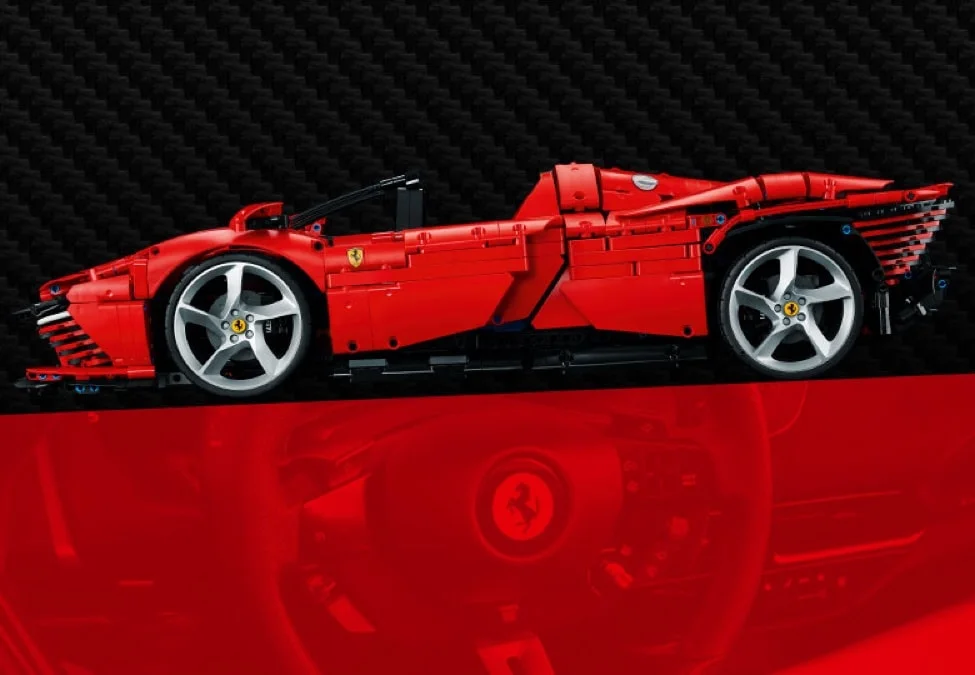 Modelul LEGO Ferrari Daytona SP3, roșu, văzut din lateral pe un fundal negru cu carbon.
