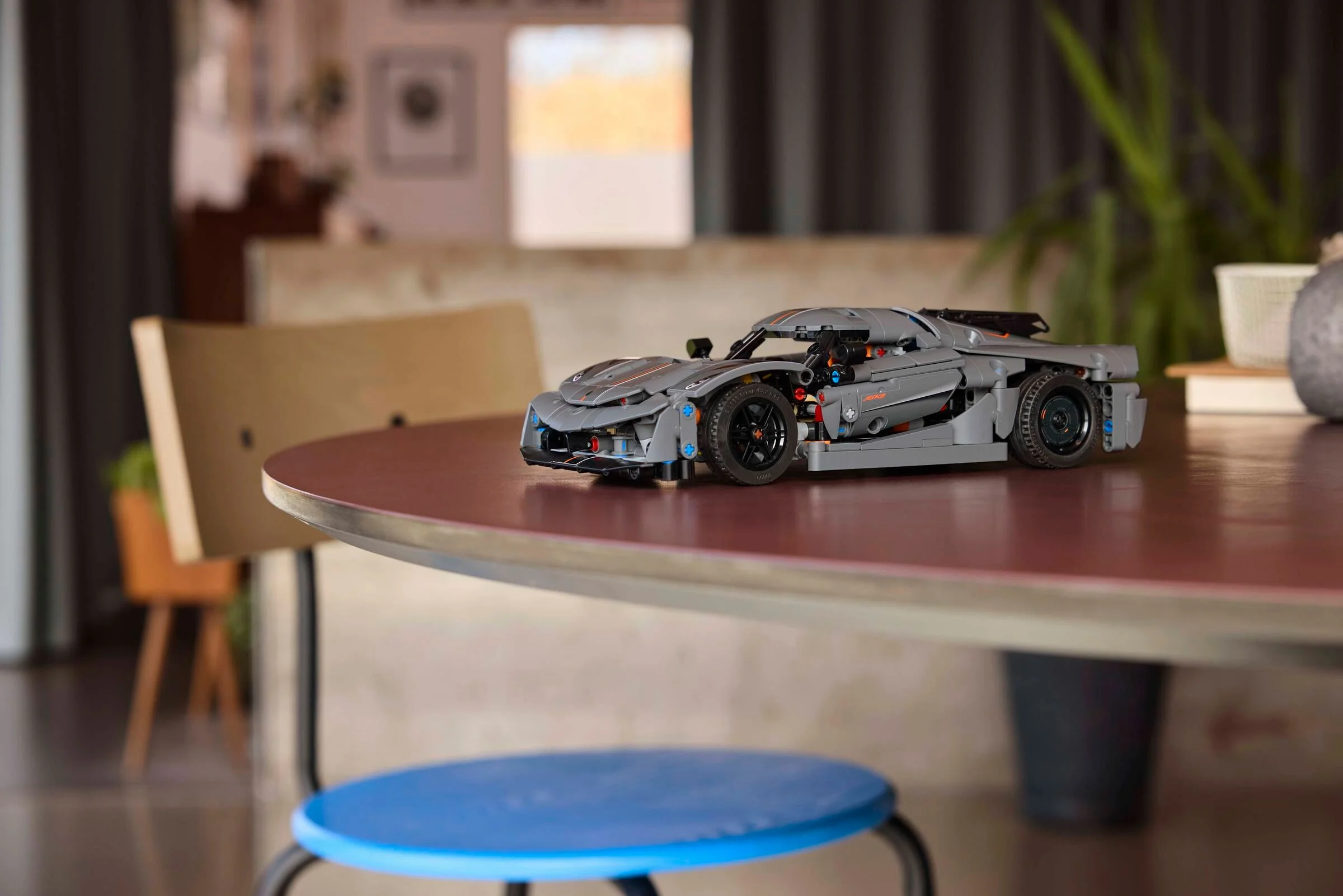 Modelul LEGO Koenigsegg Jesko Absolut gri, expus pe o masă rotundă într-un interior modern.