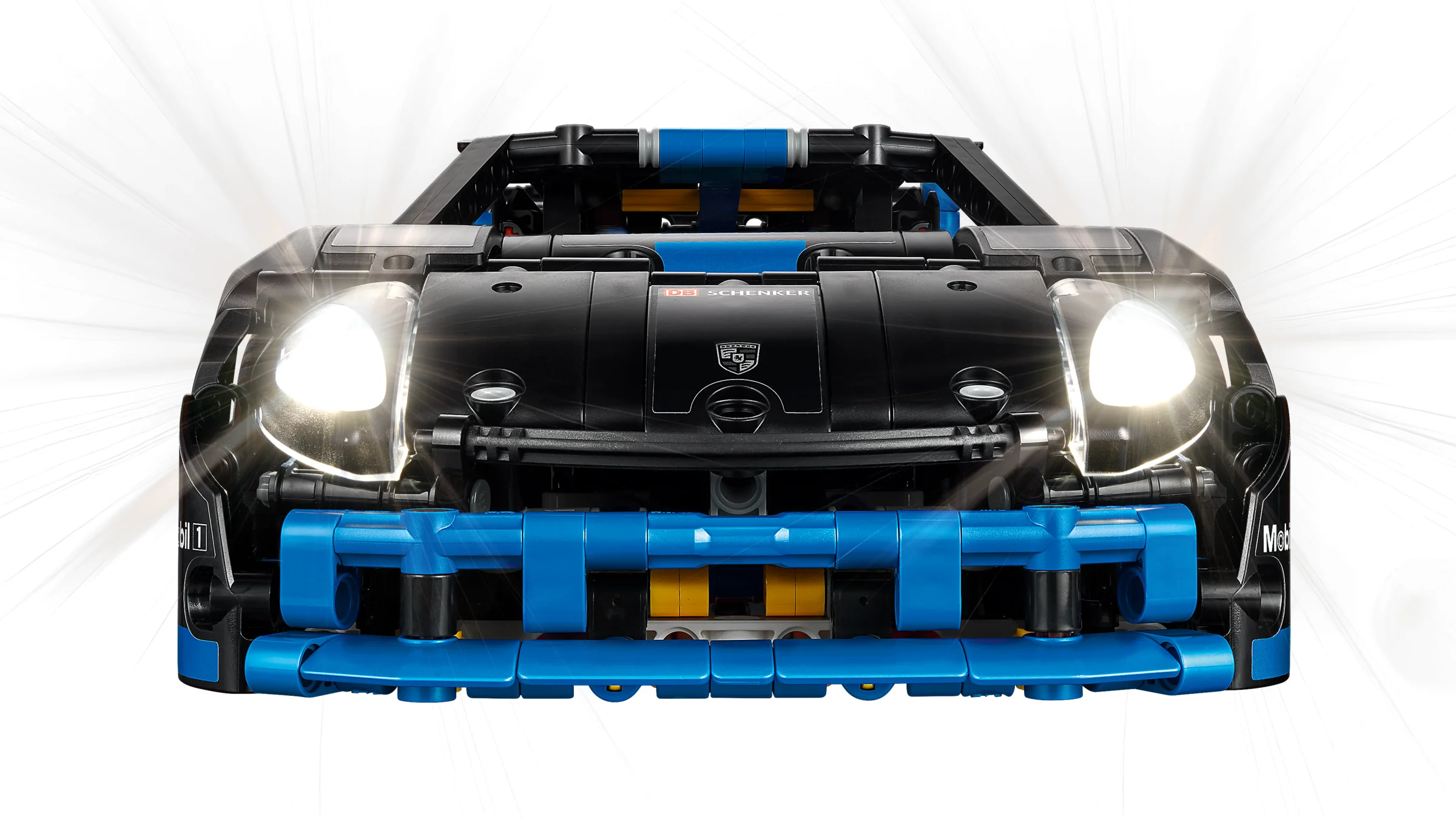 Prim-plan cu farurile aprinse ale mașinii Porsche GT4 e-Performance din LEGO Technic.