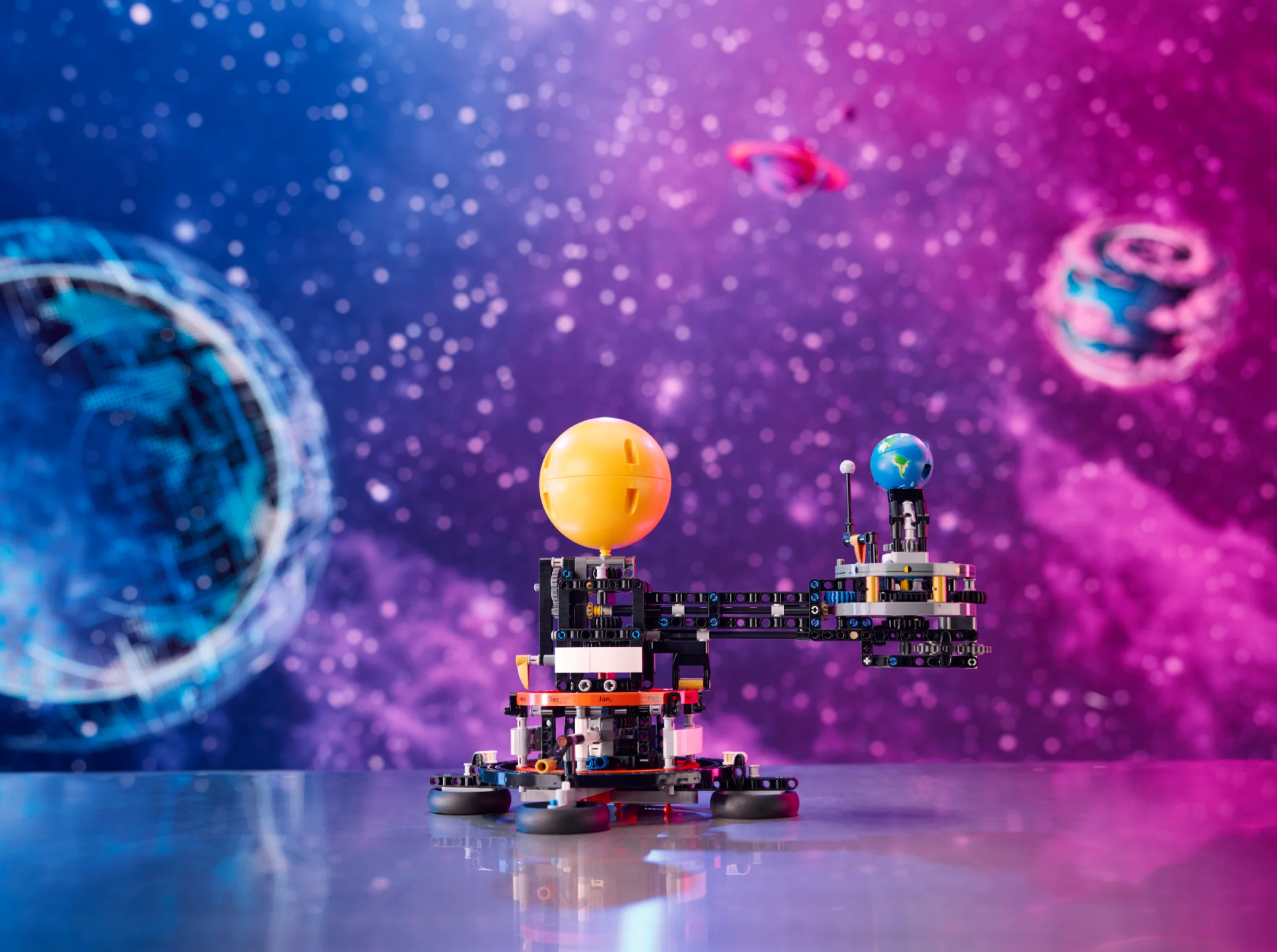Modelul LEGO Technic cu Pământul și Luna în orbită, sub fundal spațial colorat.