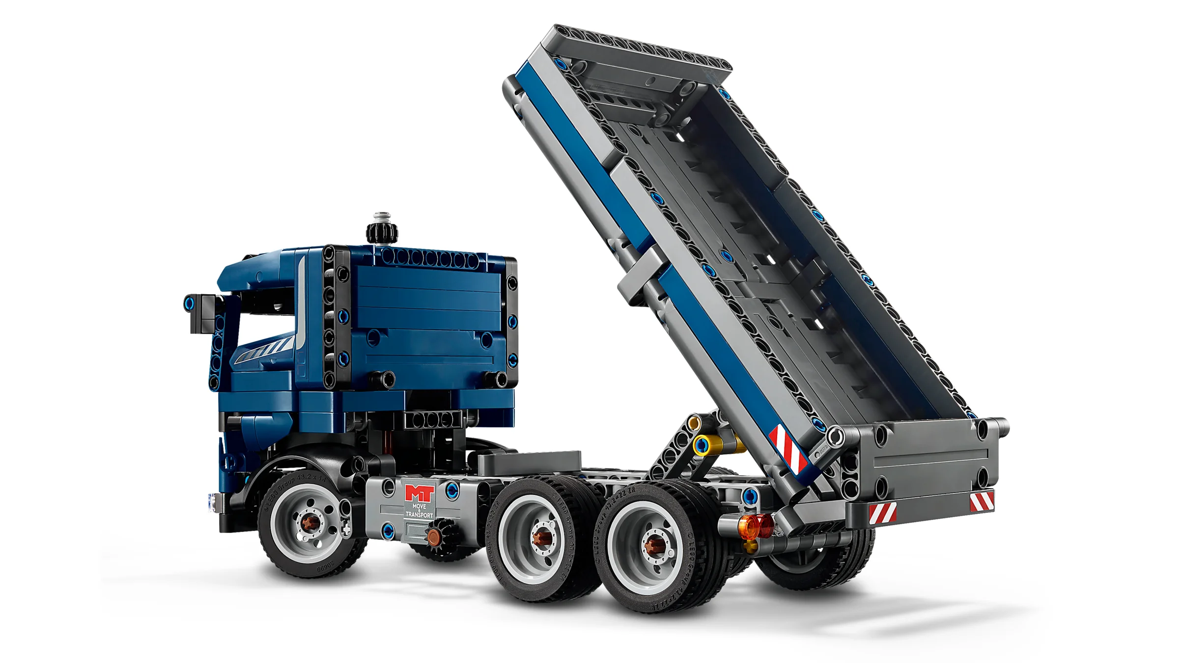 Camion basculant albastru Technic cu bena ridicată, prezentând funcția de basculare.