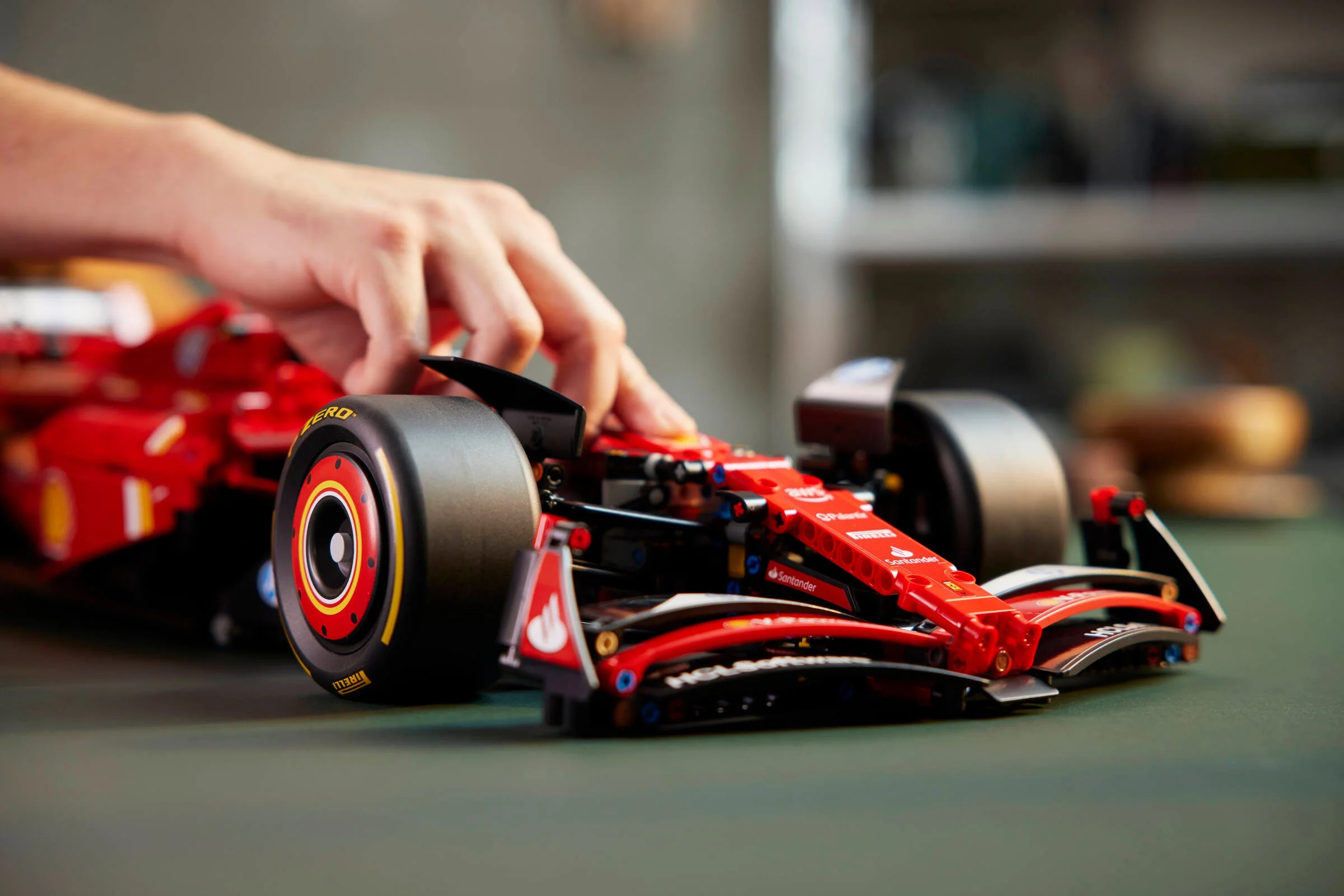 Prim-plan cu Ferrari SF-24, cu o mână arătând detaliile. Aspect realist și finisaje detaliate.
